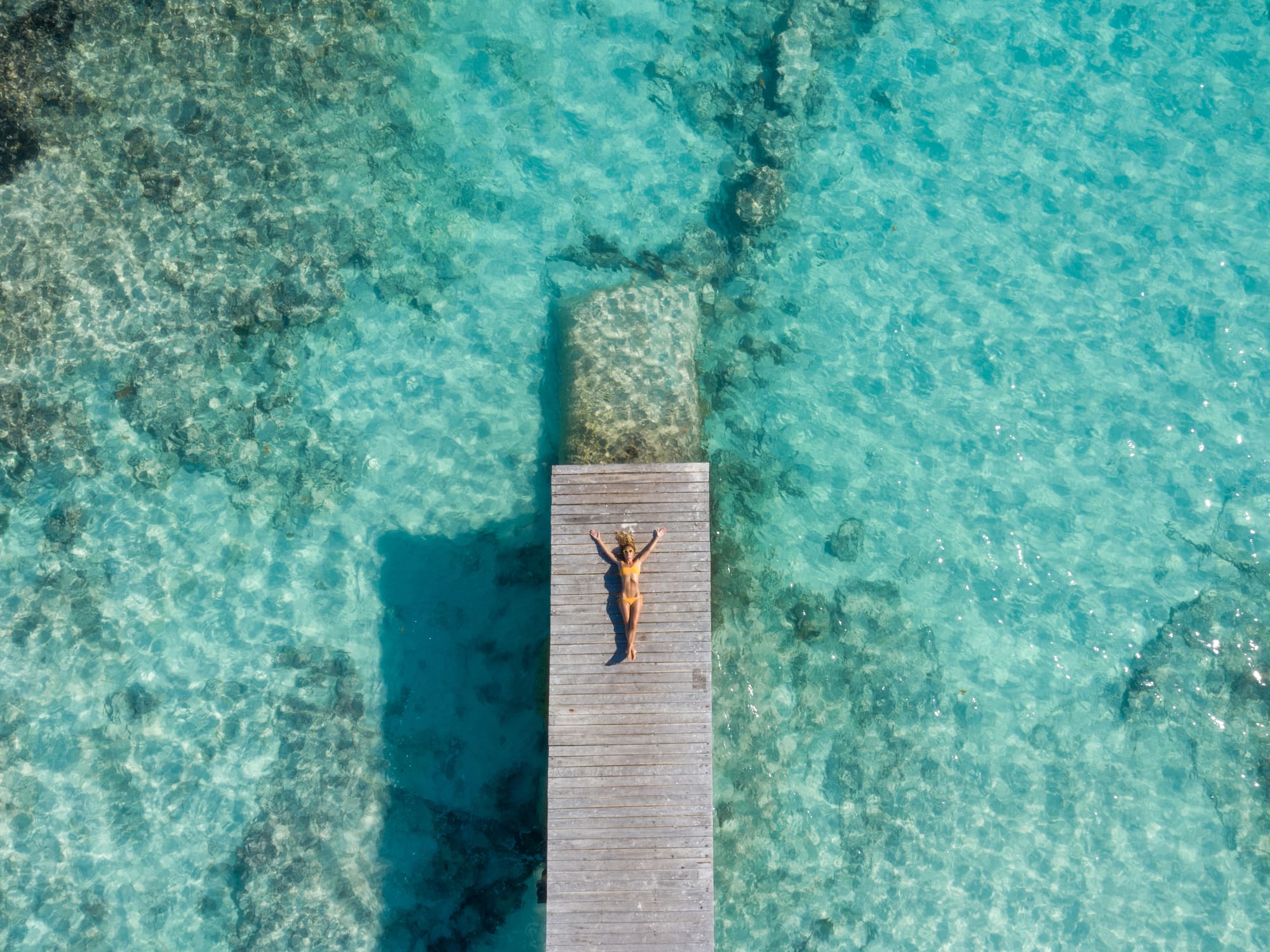 a woman lying on a dock in the water