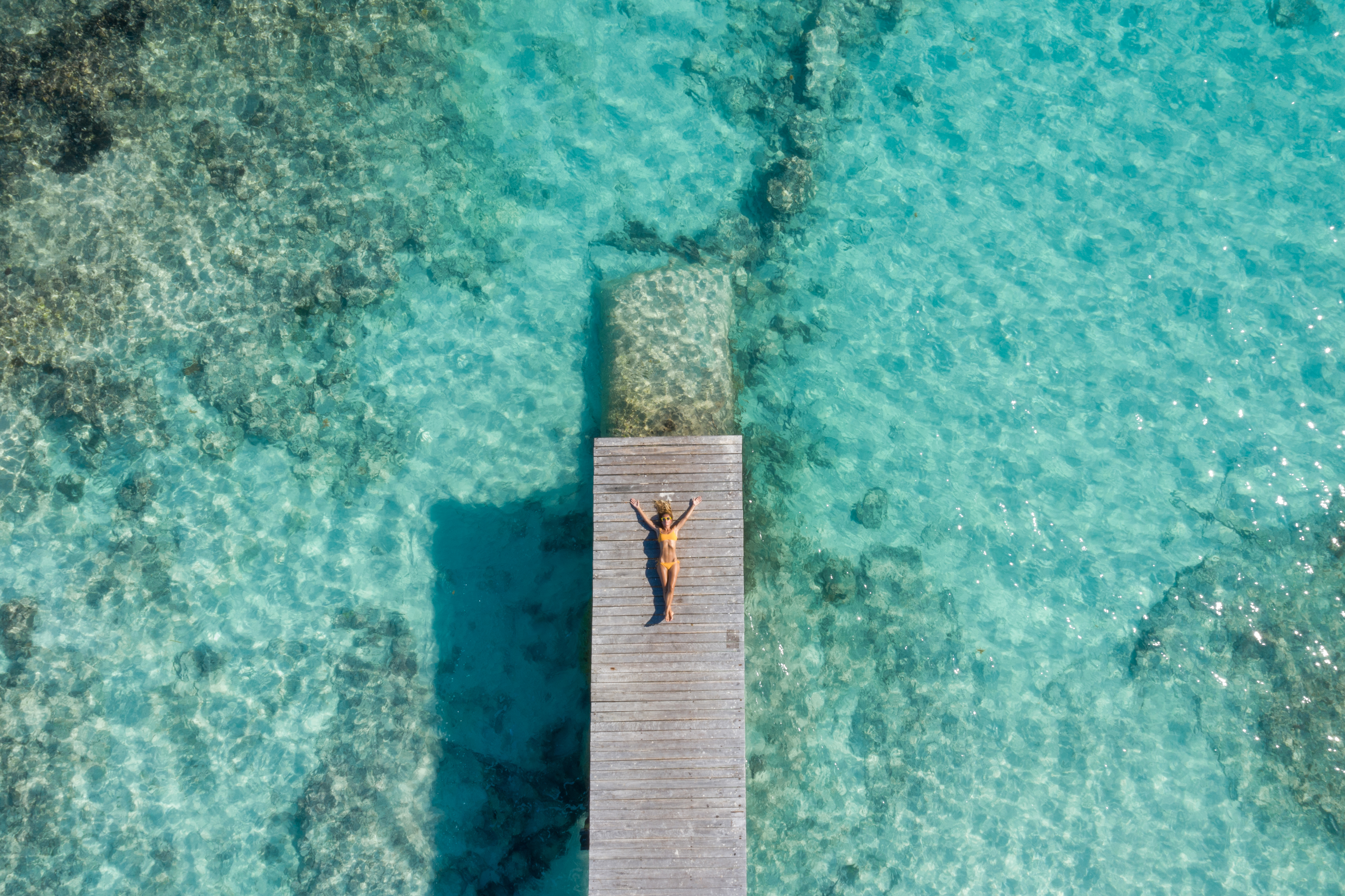 a woman lying on a dock in the water