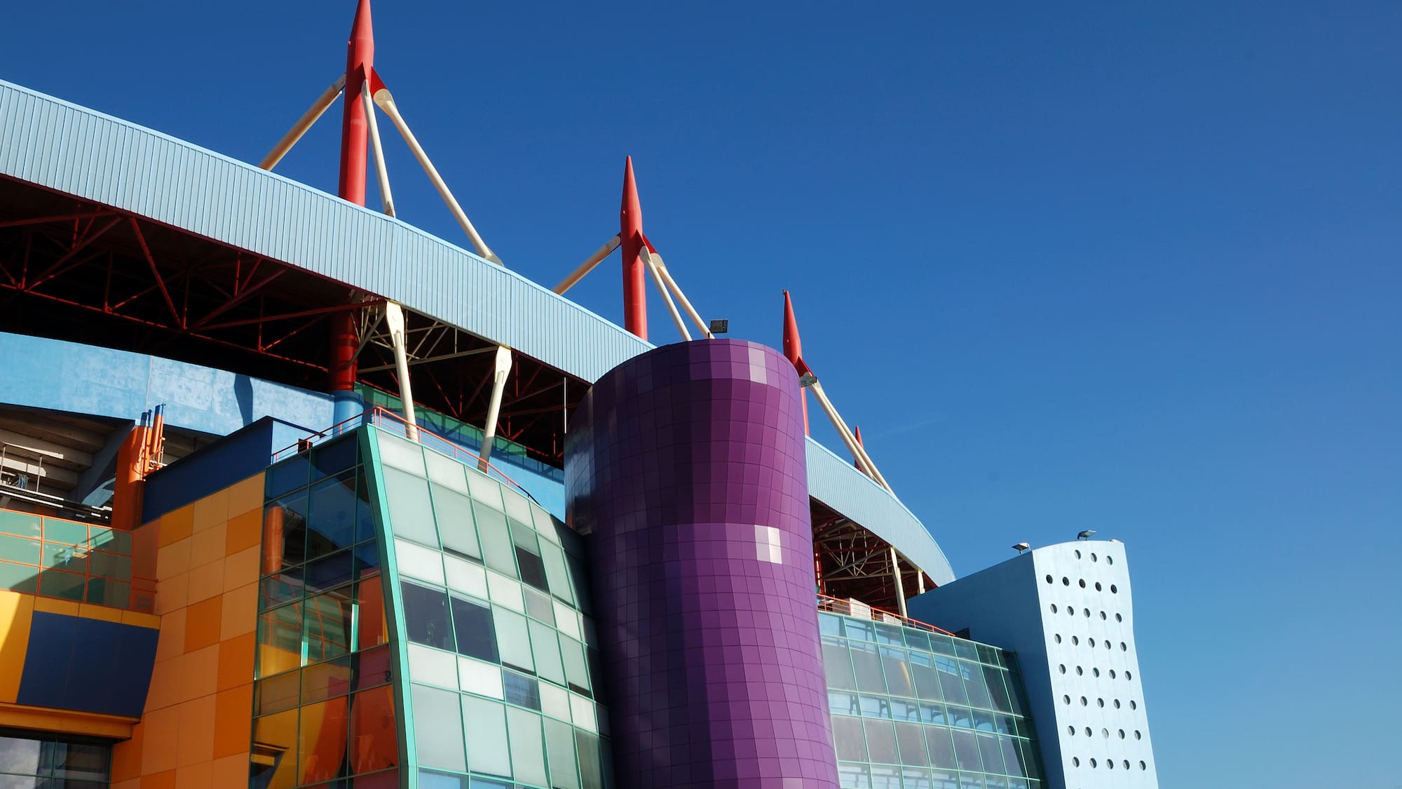 a multi colored building with red poles