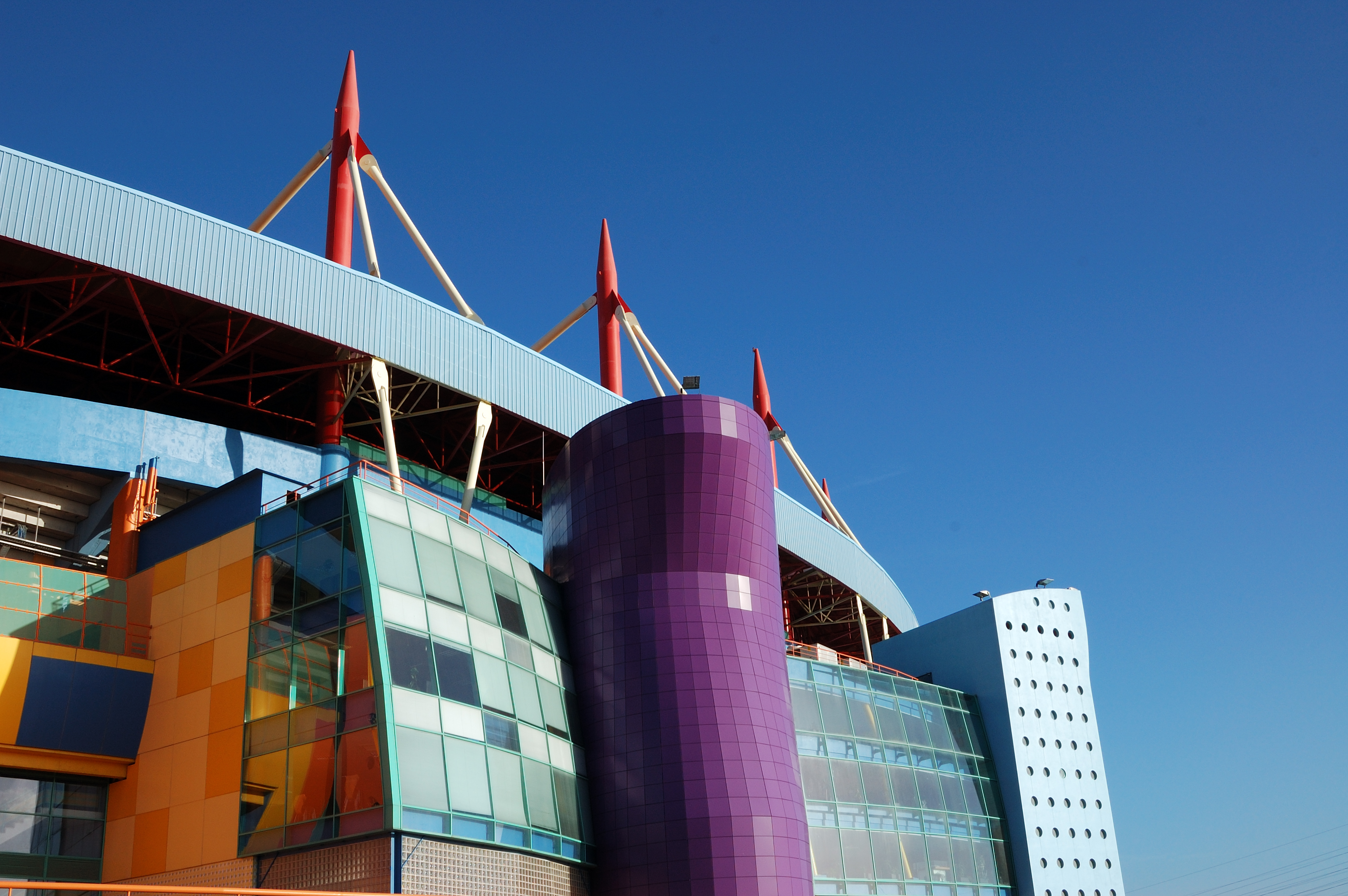 a multi colored building with red poles