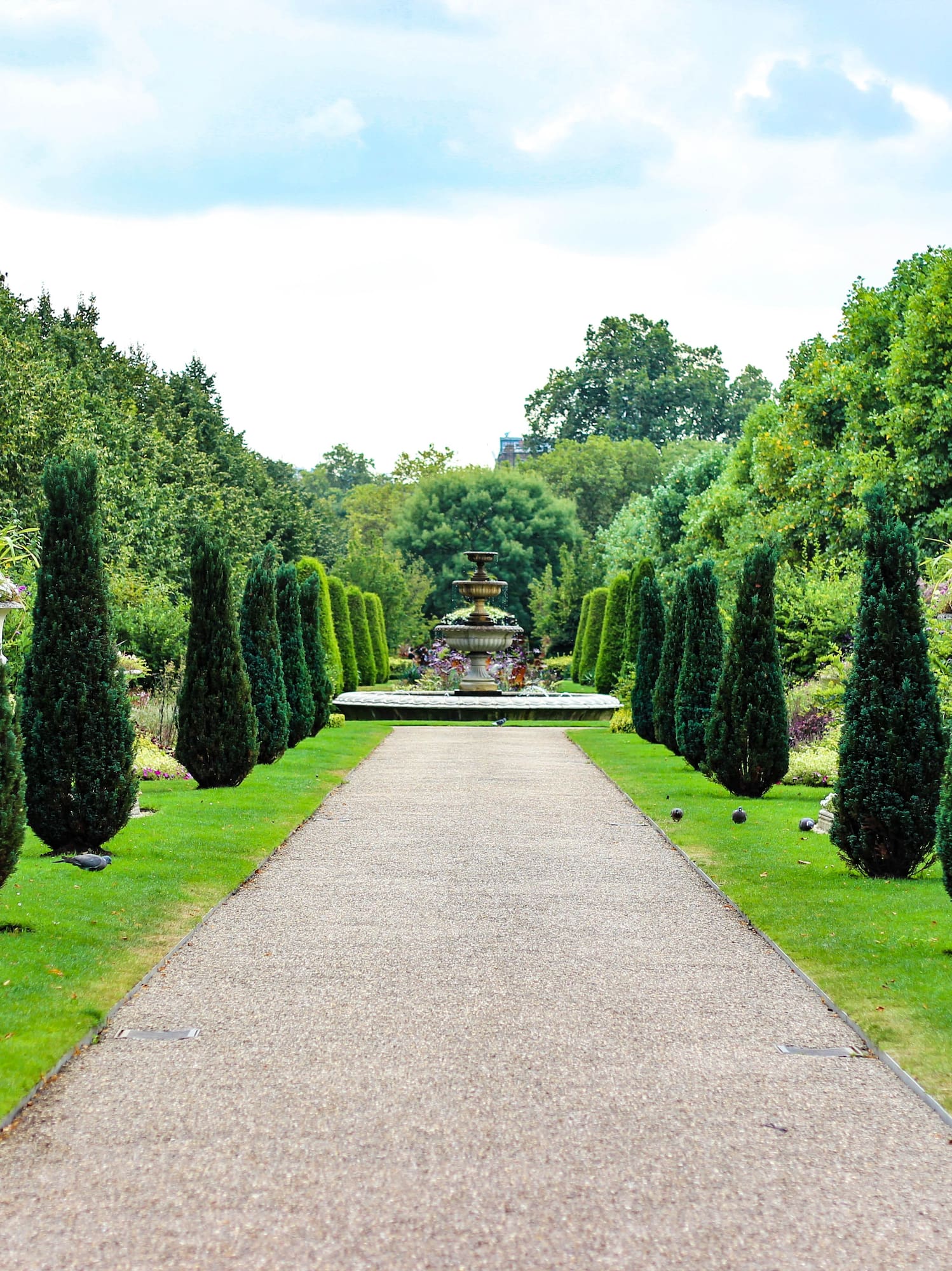 a path with a fountain and trees