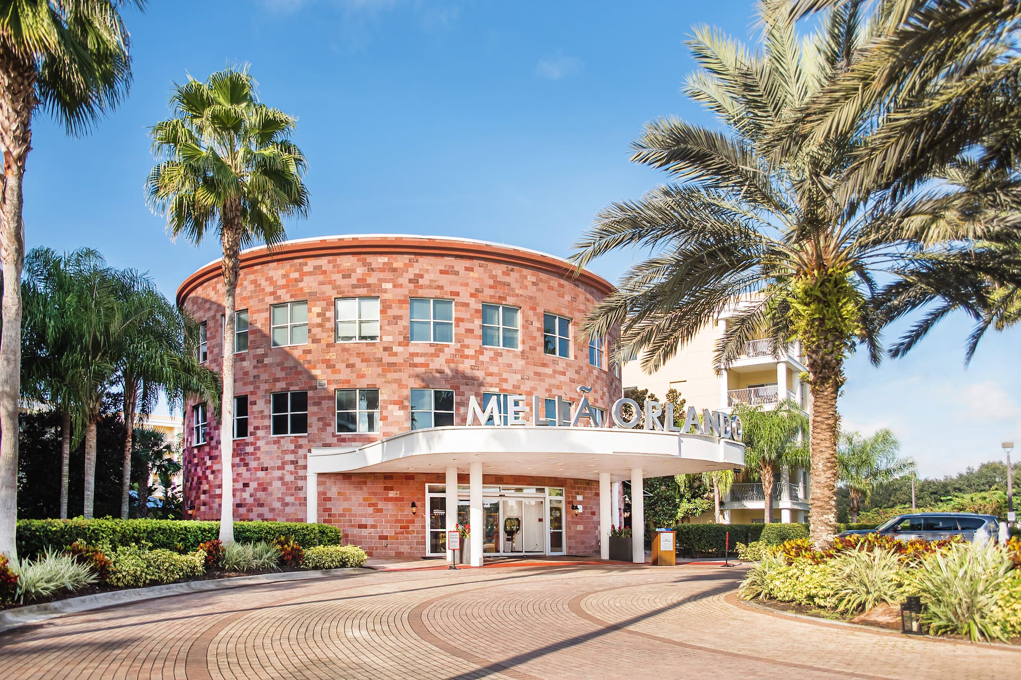 Meliá Orlando hotel exterior, circular brick building, palm trees.