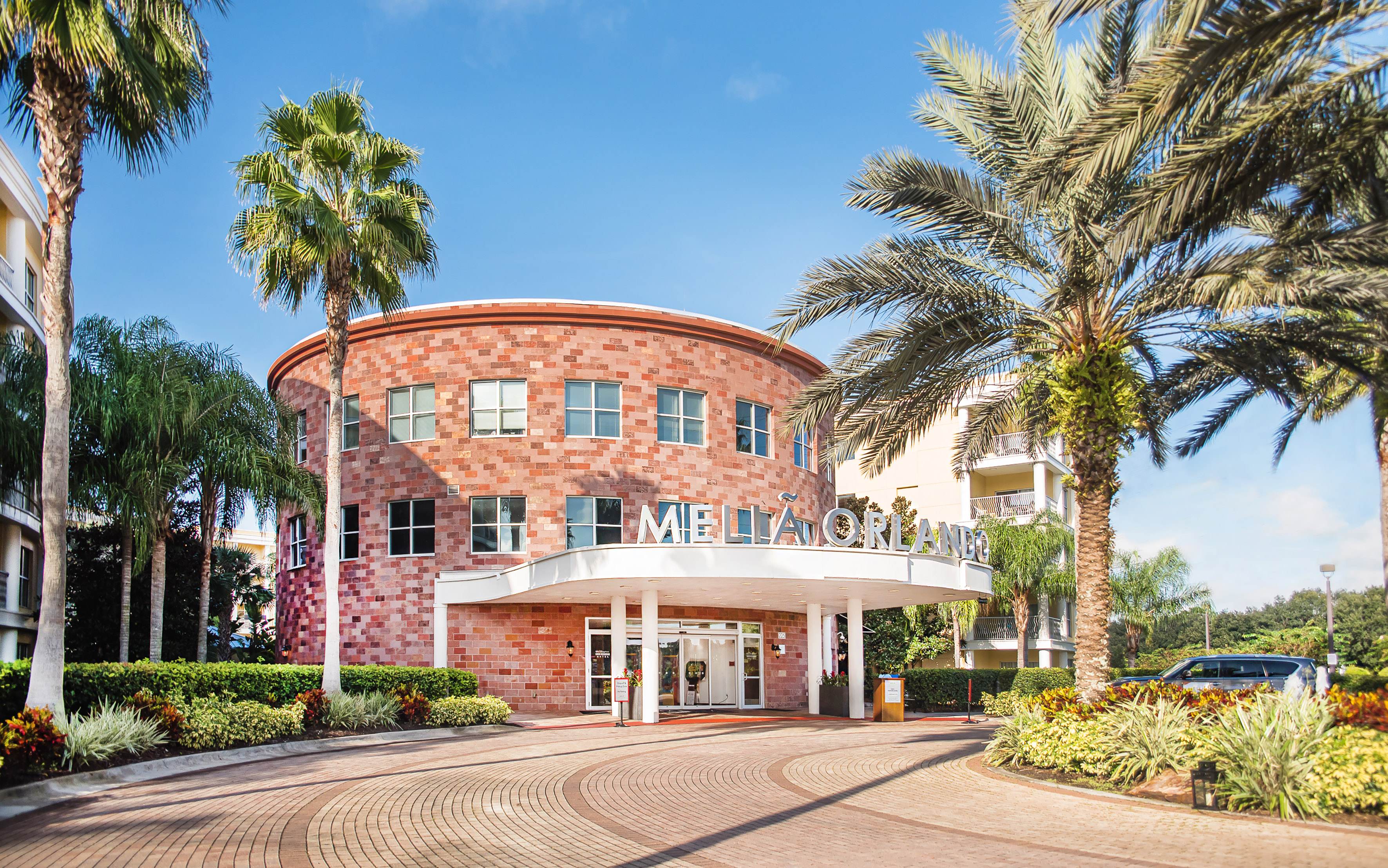 Meliá Orlando hotel exterior, circular brick building, palm trees.