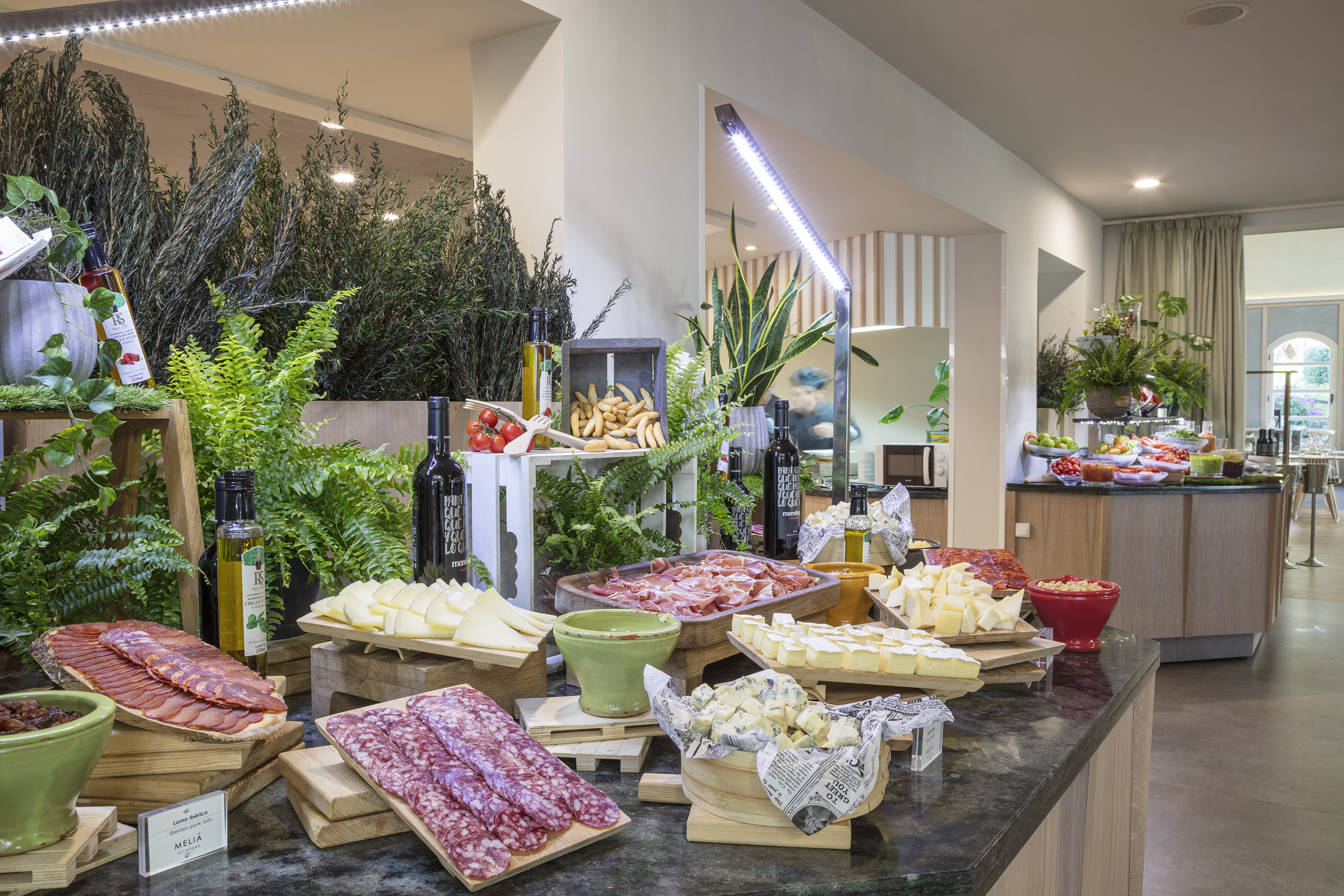 Gourmet hotel buffet featuring charcuterie, cheeses, olive oil, and fresh items.