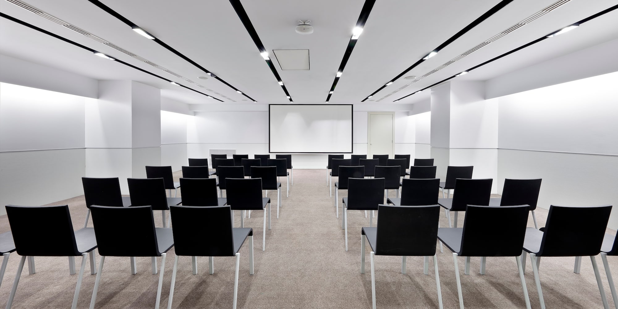 a room with chairs and a projector screen