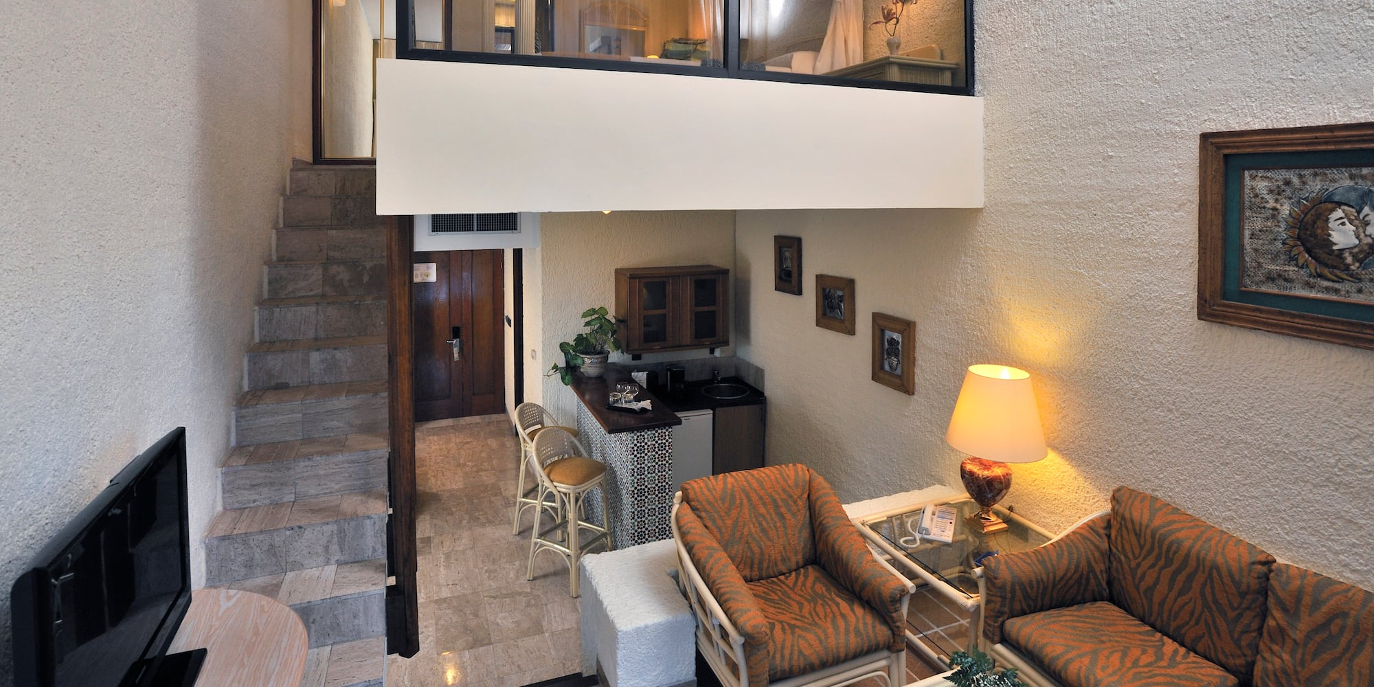 a room with a loft and a couch and chairs