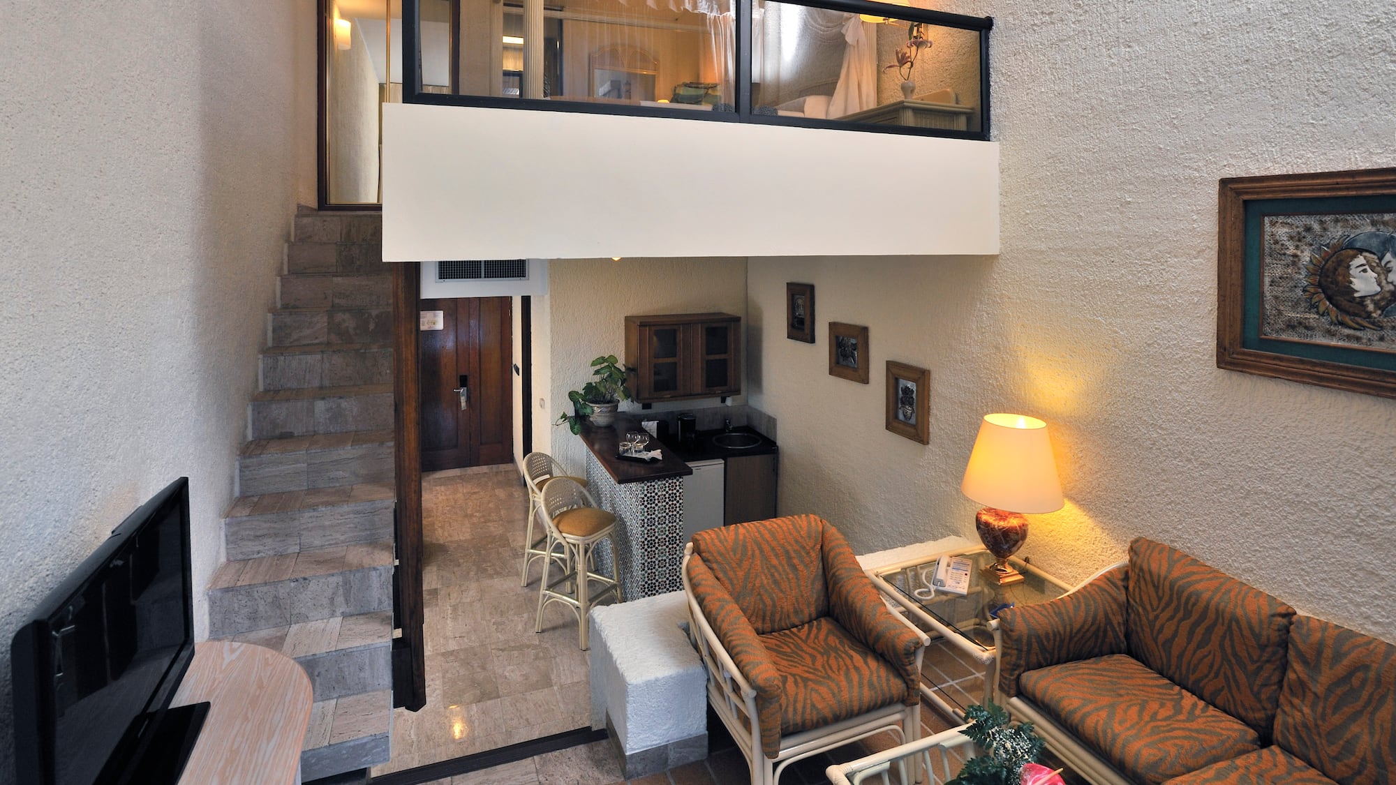 a room with a loft and a couch and chairs