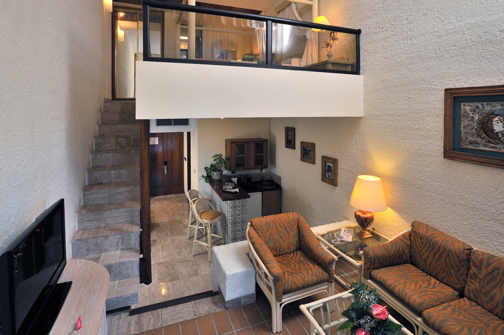 a room with a loft and a couch and chairs