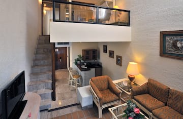 a room with a loft and a couch and chairs