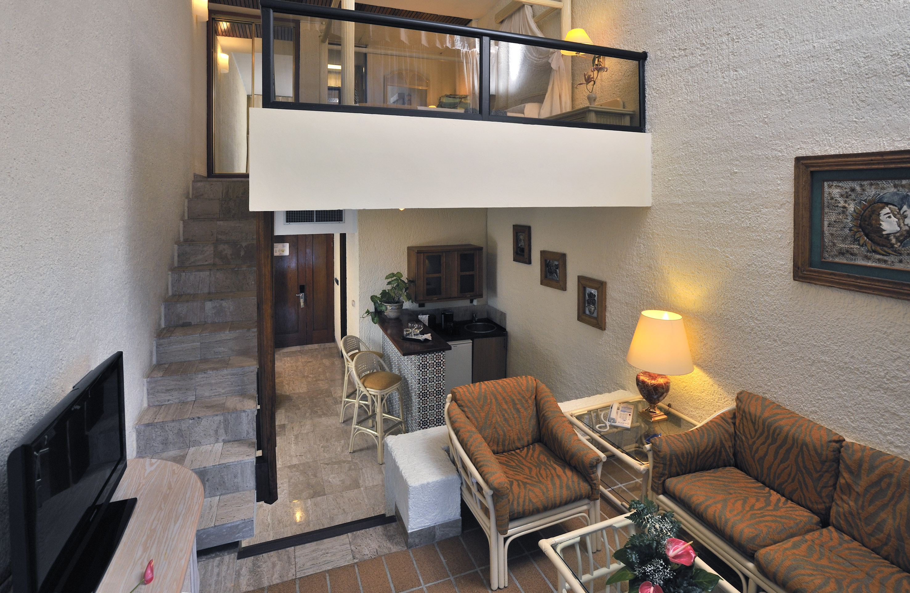 a room with a loft and a couch and chairs