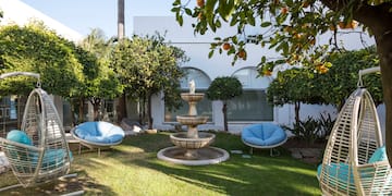 a fountain in a yard with chairs and a fountain