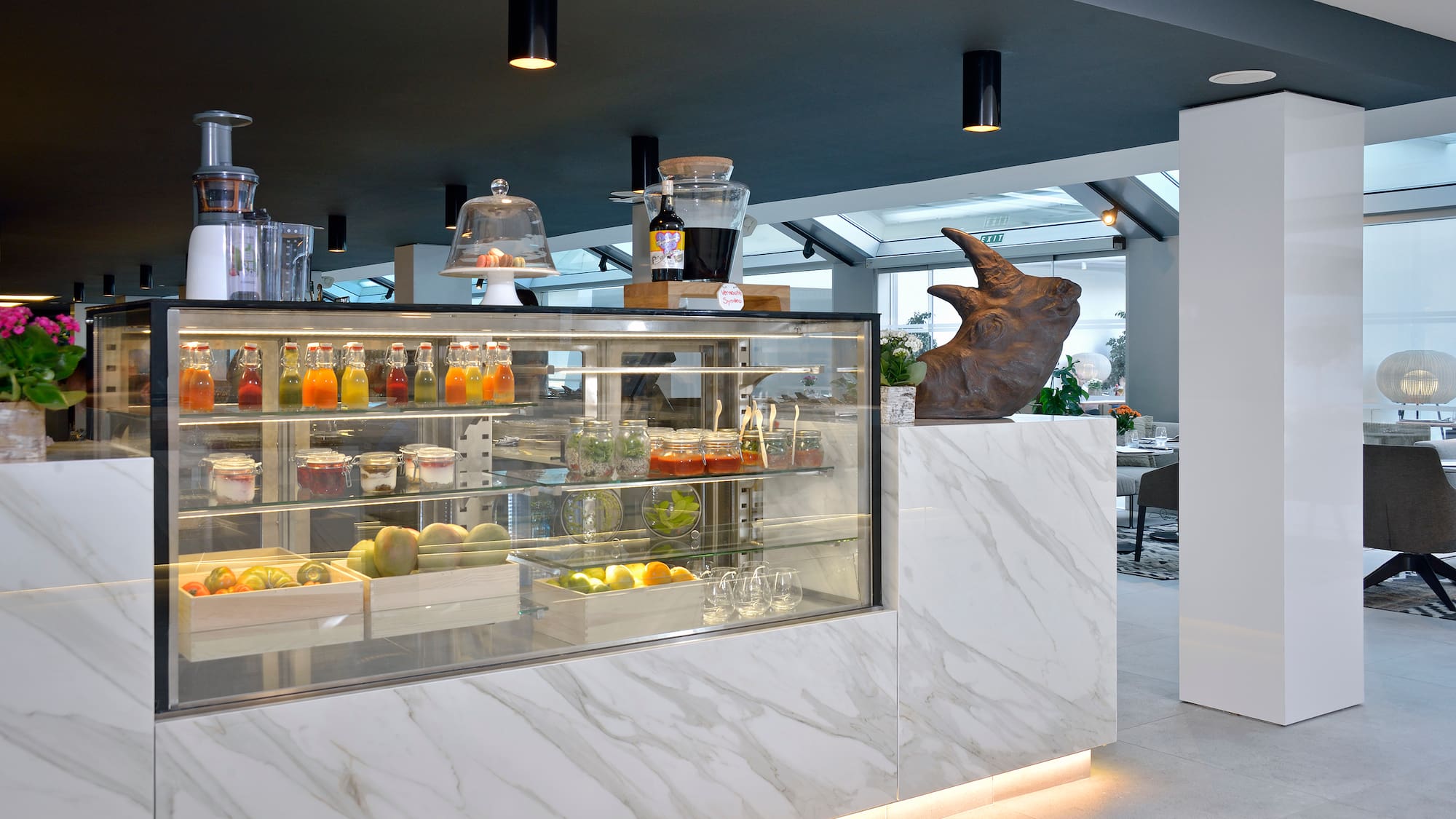 a display case with drinks and a statue of a rhinoceros