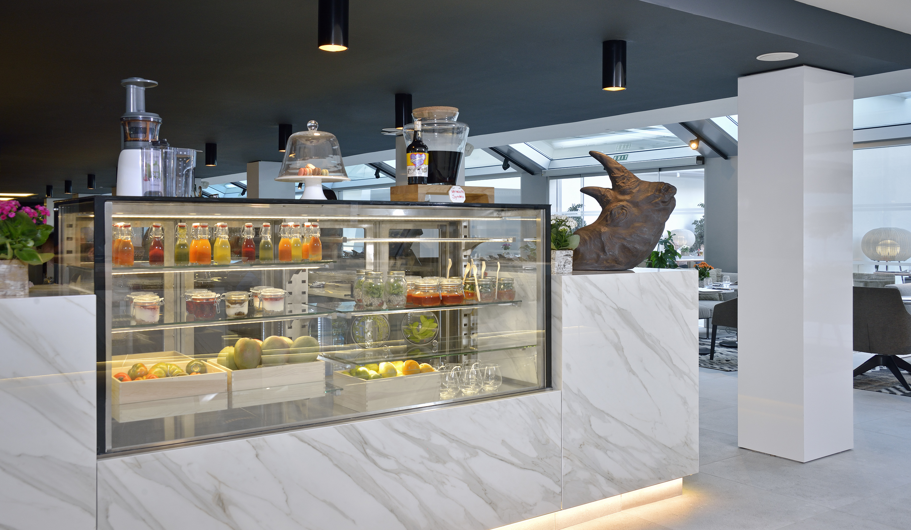 a display case with drinks and a statue of a rhinoceros