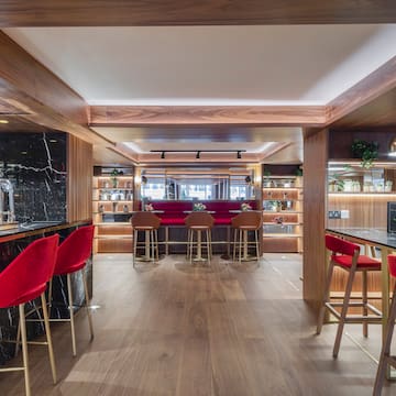 a bar with red chairs and a counter