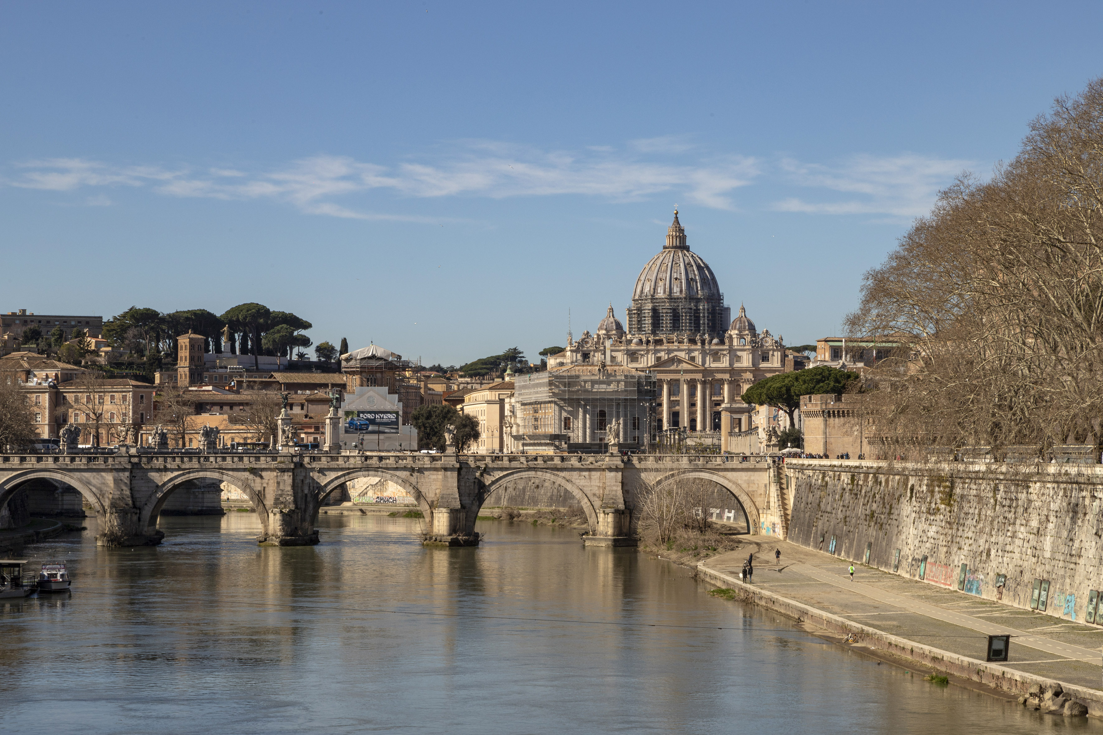 Rome cityscape with St. Peter's Basilica, Tiber River, and arched stone bridge.