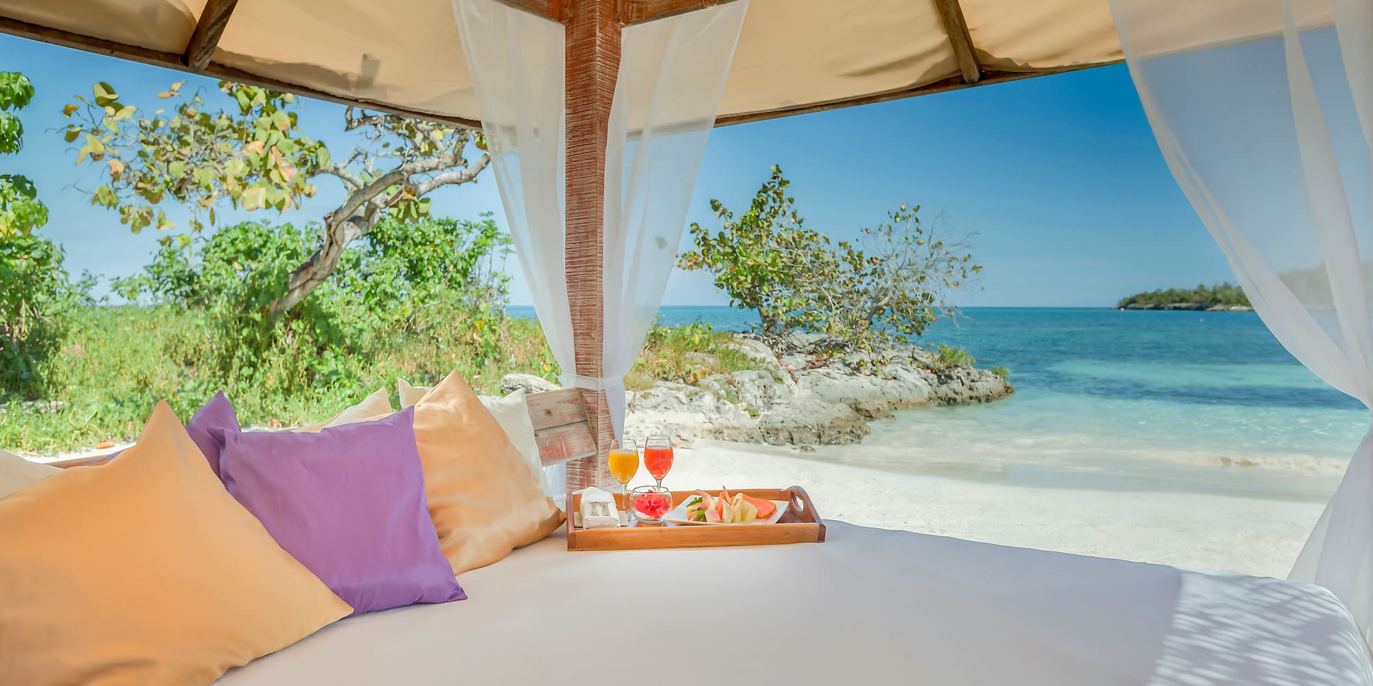 a bed with a tray of food and drinks on it