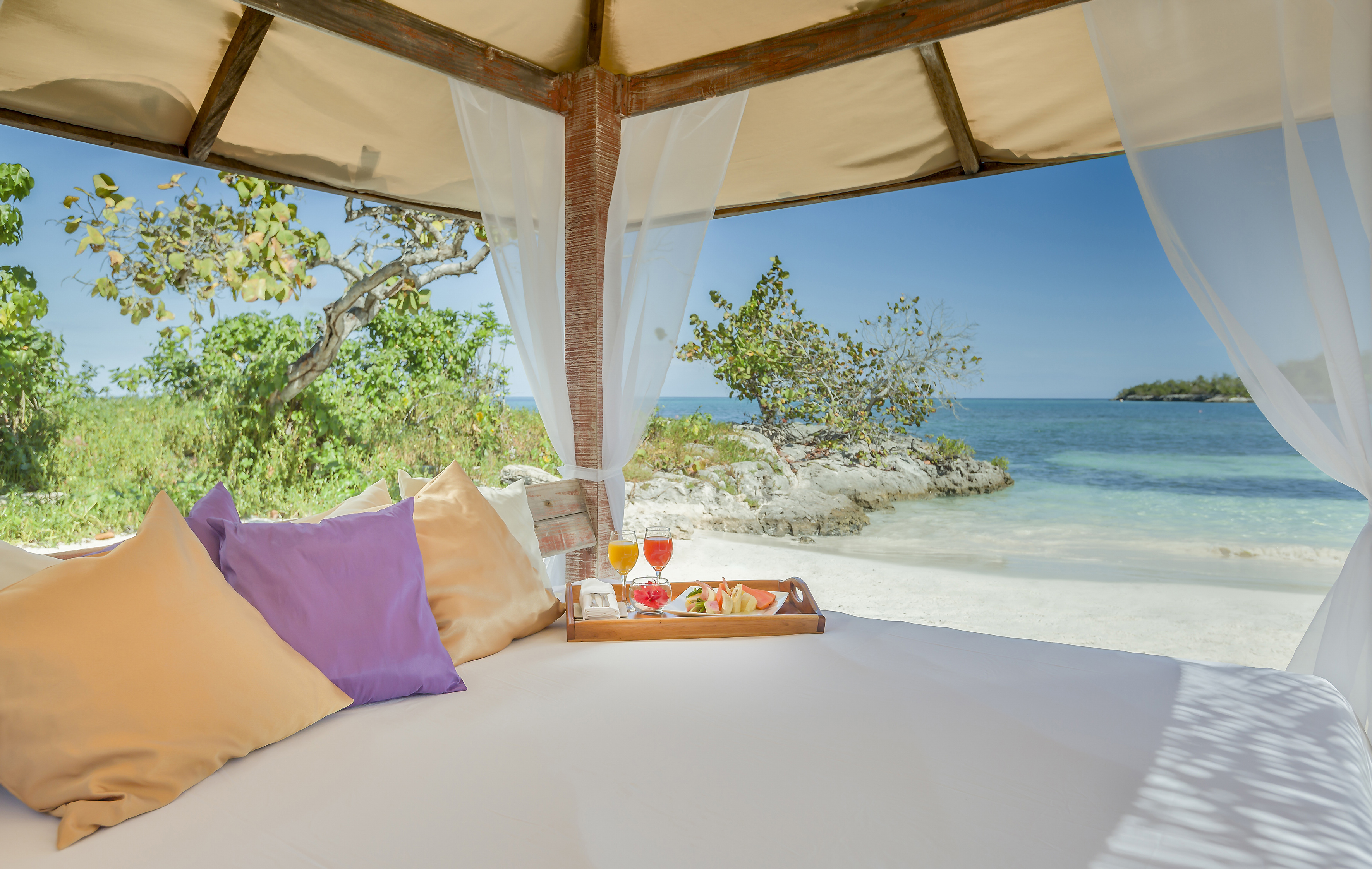 a bed with a tray of food and drinks on it