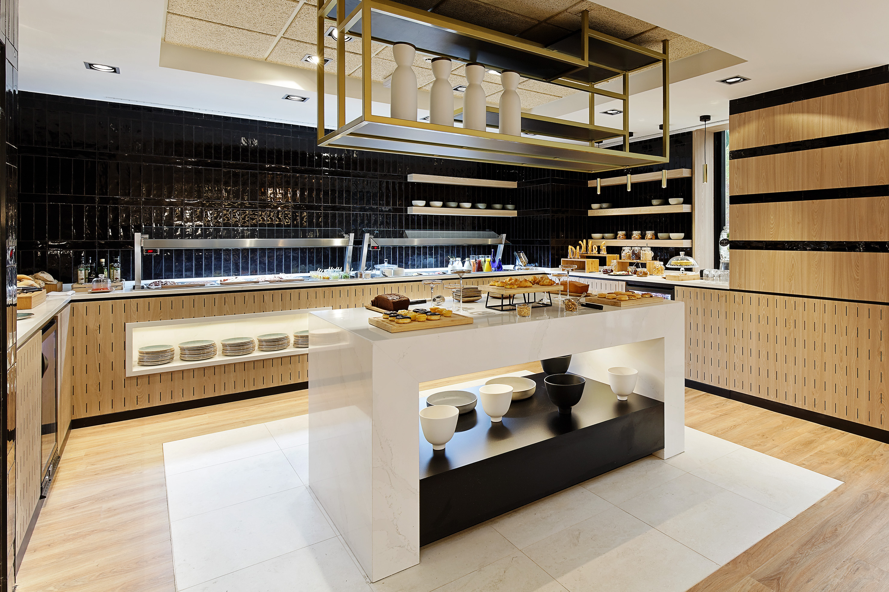 Modern hotel breakfast buffet with pastries, fresh foods, and stylish interior.