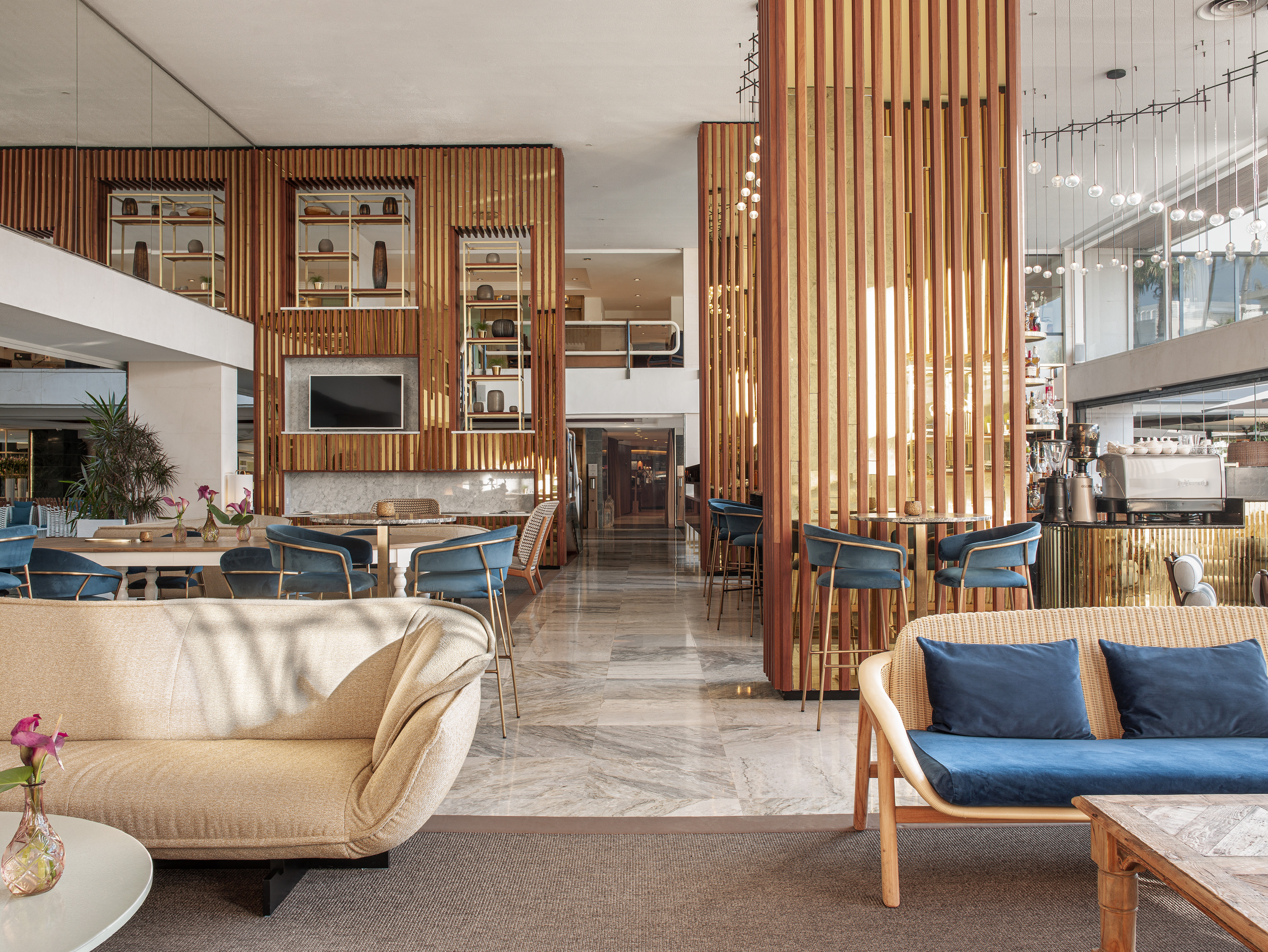 Modern hotel interior with wooden screens, stylish seating, marble floor, bar.