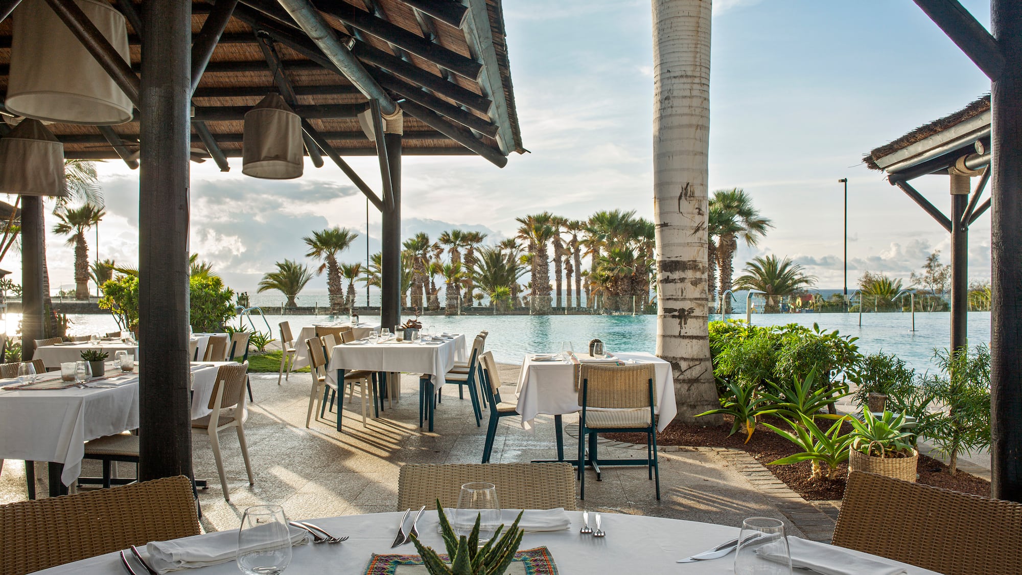 a restaurant with tables and chairs and a pool
