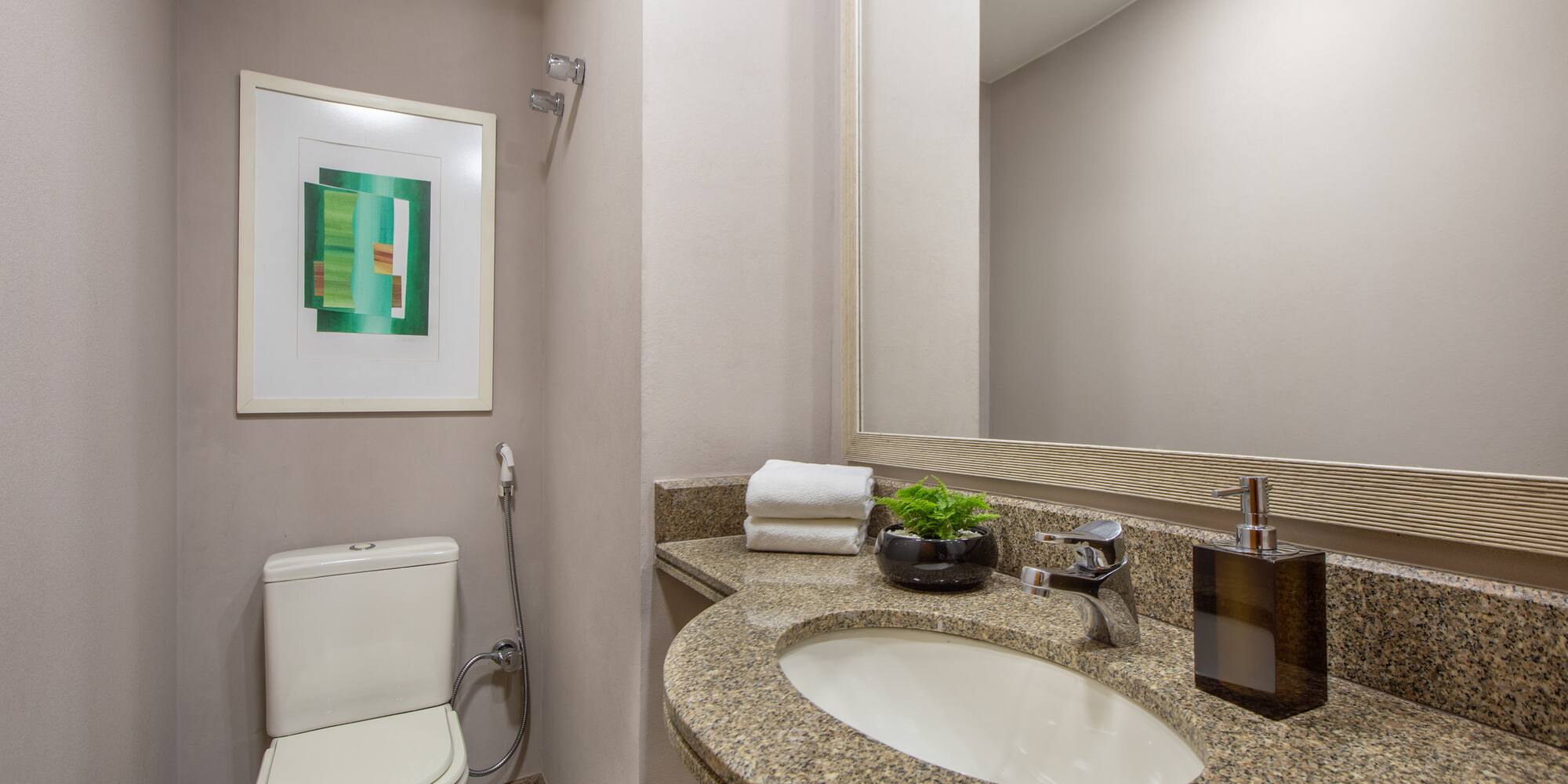 a bathroom with a marble countertop sink and a toilet