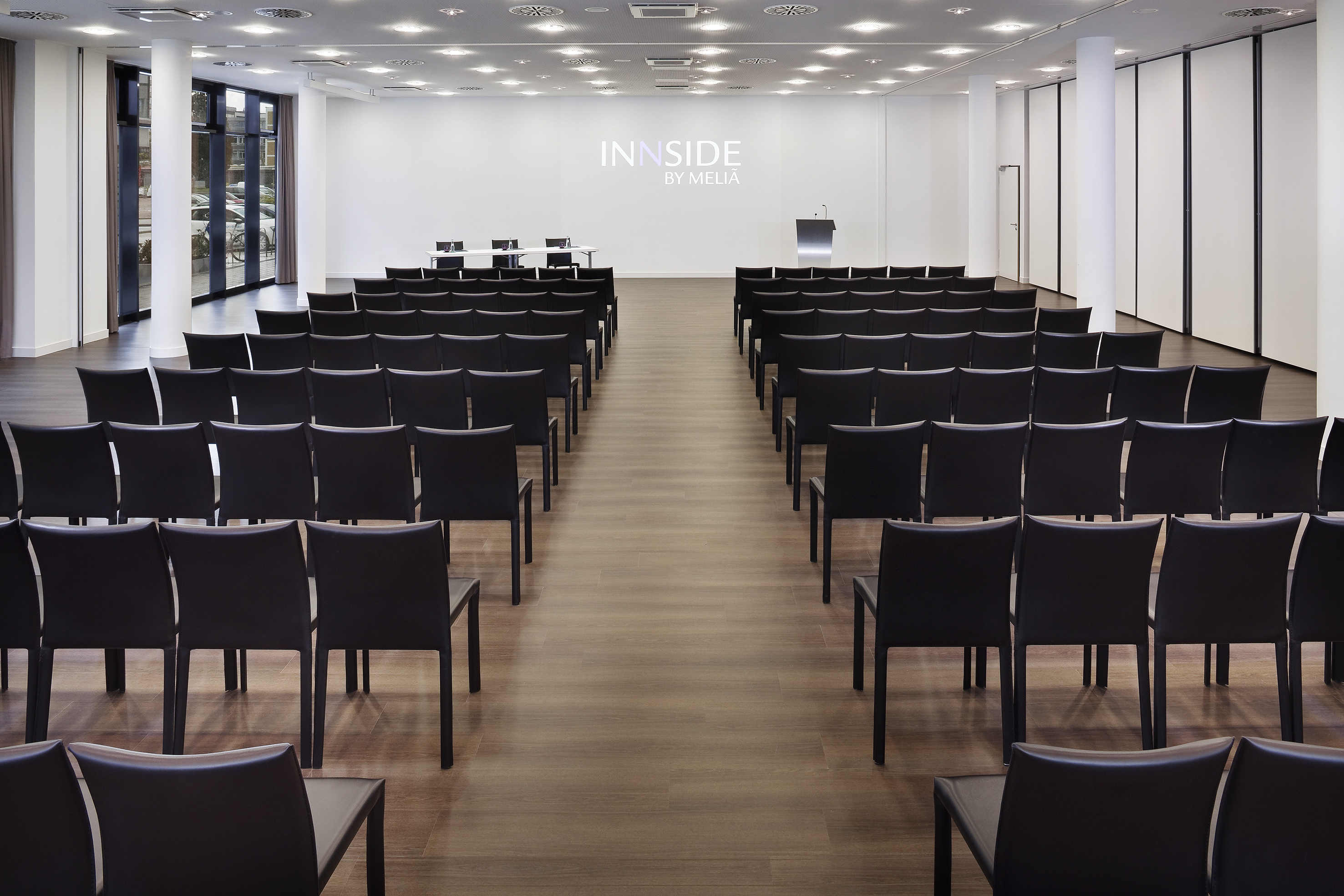 INNSIDE by Melia conference room with rows of empty black chairs.