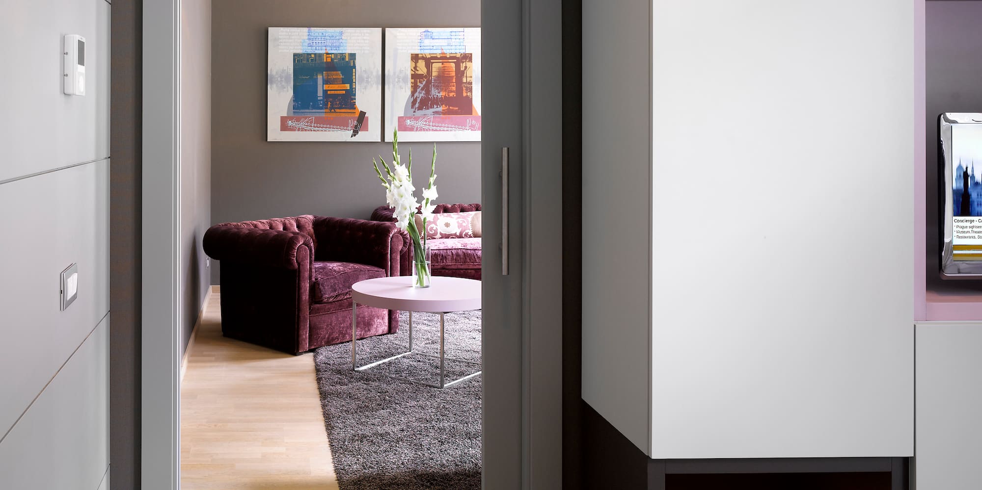 a room with a door open and a couch and a tv