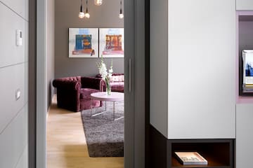 a room with a door open and a couch and a tv