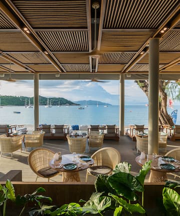 a restaurant with tables and chairs and a view of the water