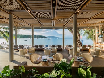 a restaurant with tables and chairs and a view of the water