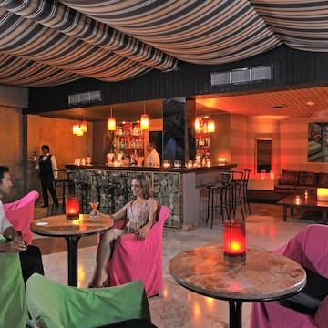 a man and woman sitting at tables in a room with a bar