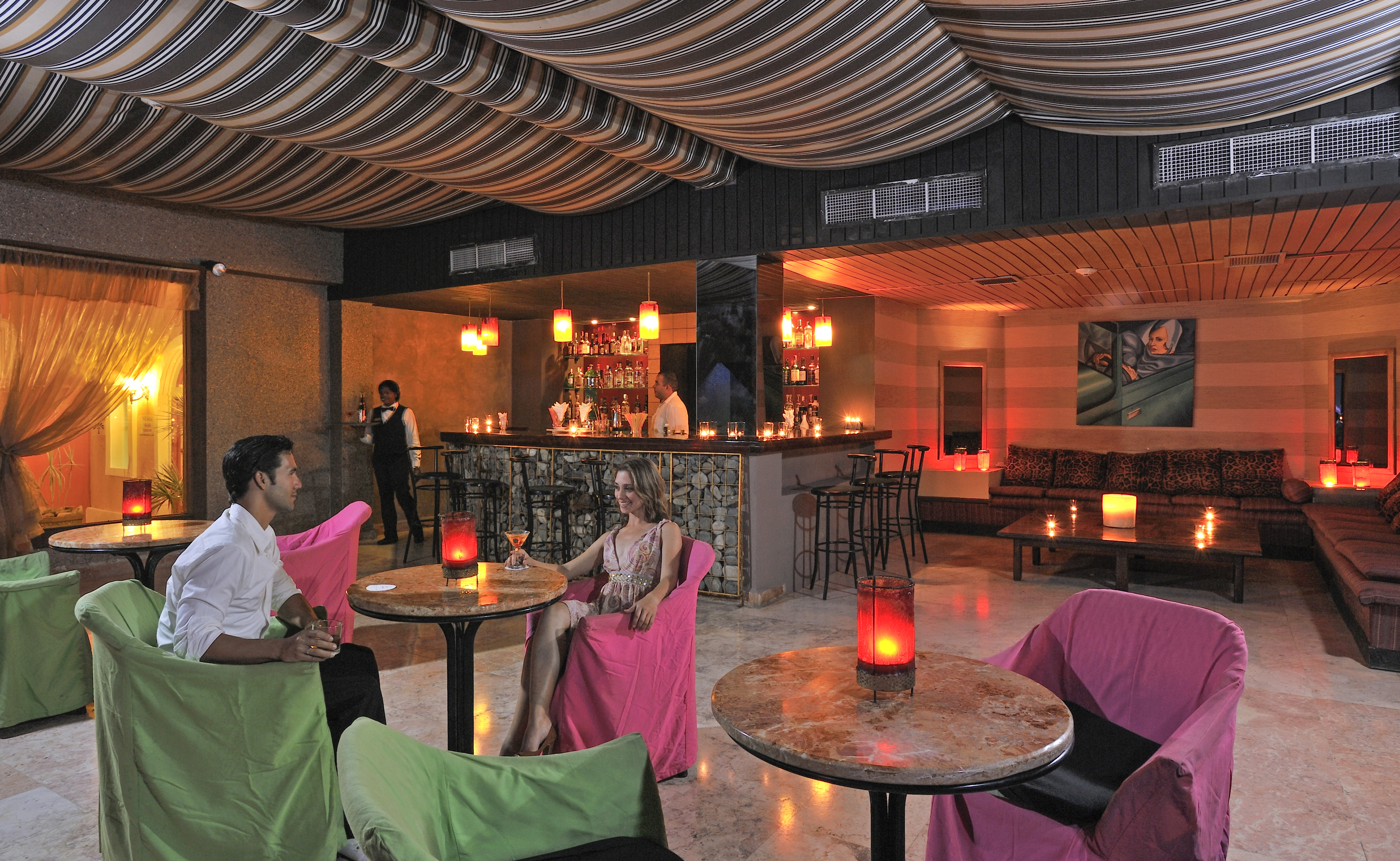 a man and woman sitting at tables in a room with a bar