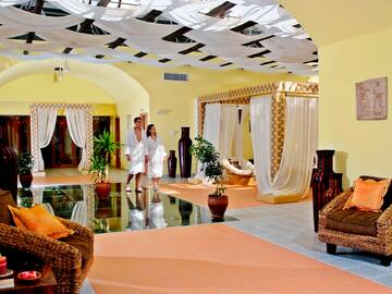 a couple in white robes in a room