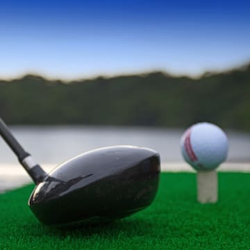 a golf club and a golf ball on a tee