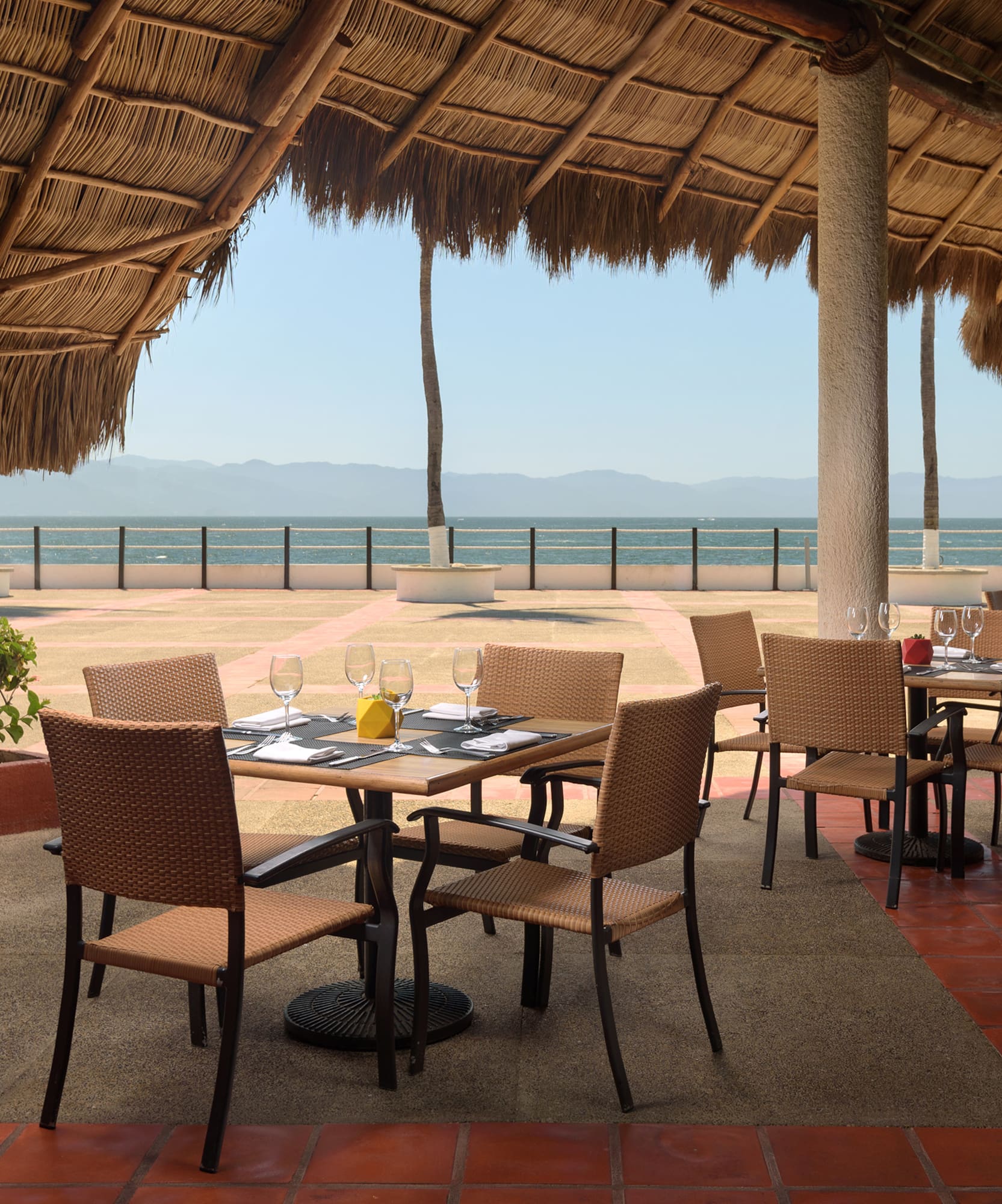 a table and chairs under a thatched roof