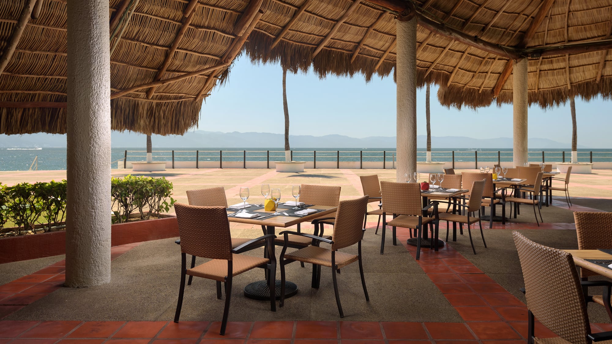 a table and chairs under a thatched roof
