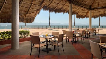 a table and chairs under a thatched roof