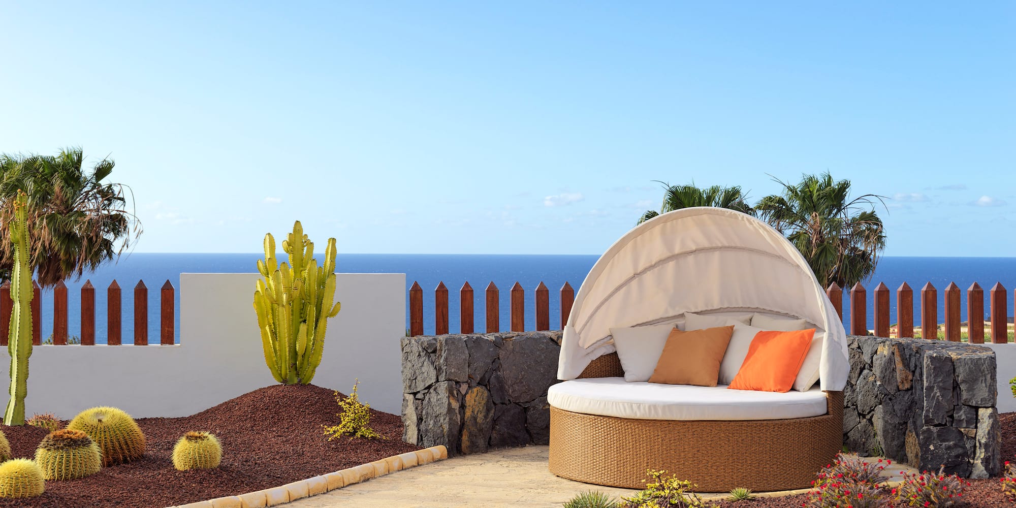 a patio with a round bed and a white canopy