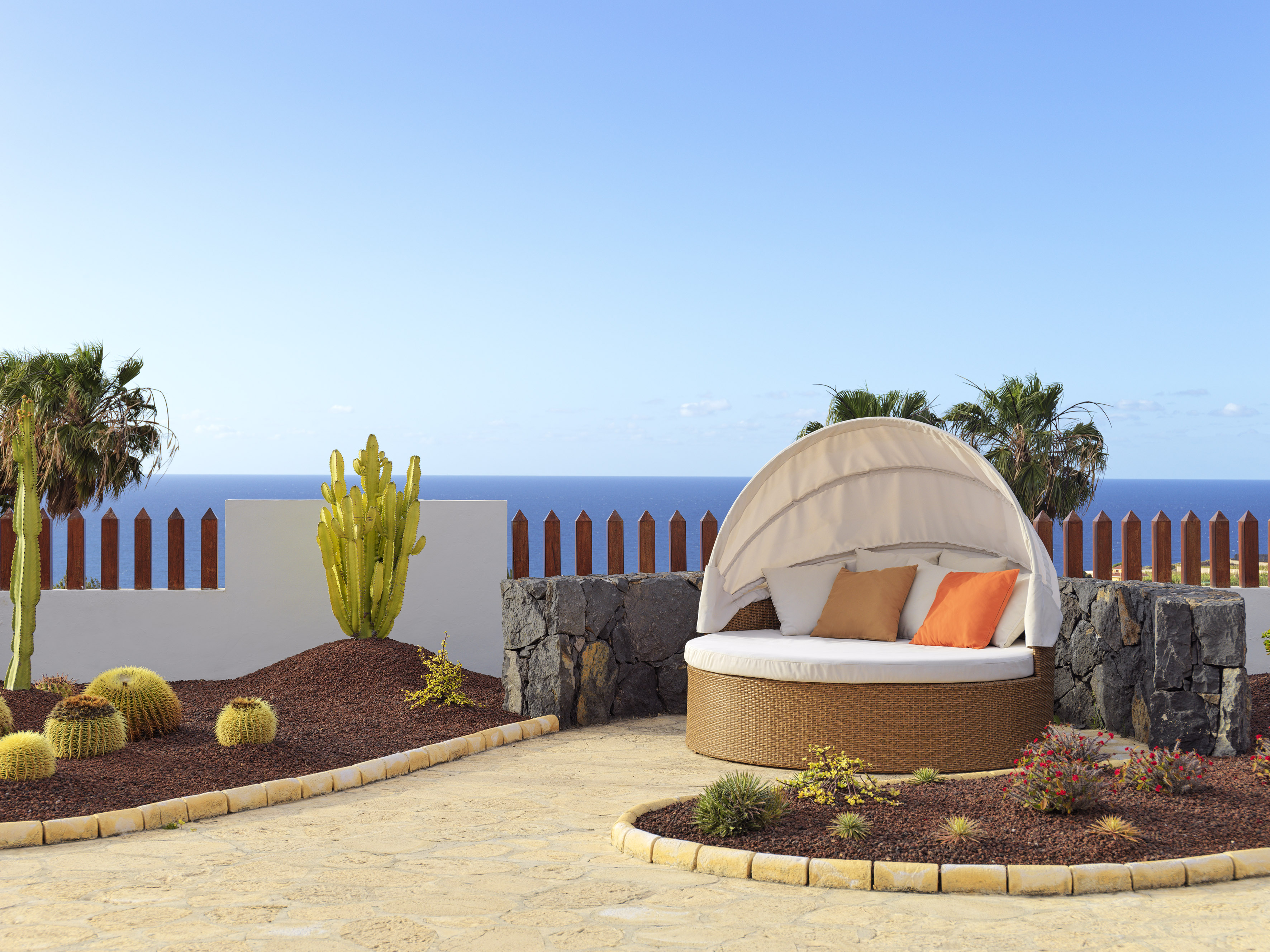 a patio with a round bed and a white canopy