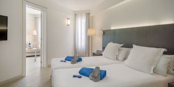 a room with two beds and a bed with a table and chairs