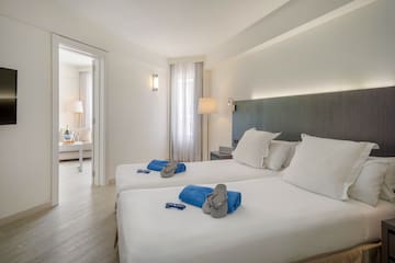 a room with two beds and a bed with a table and chairs