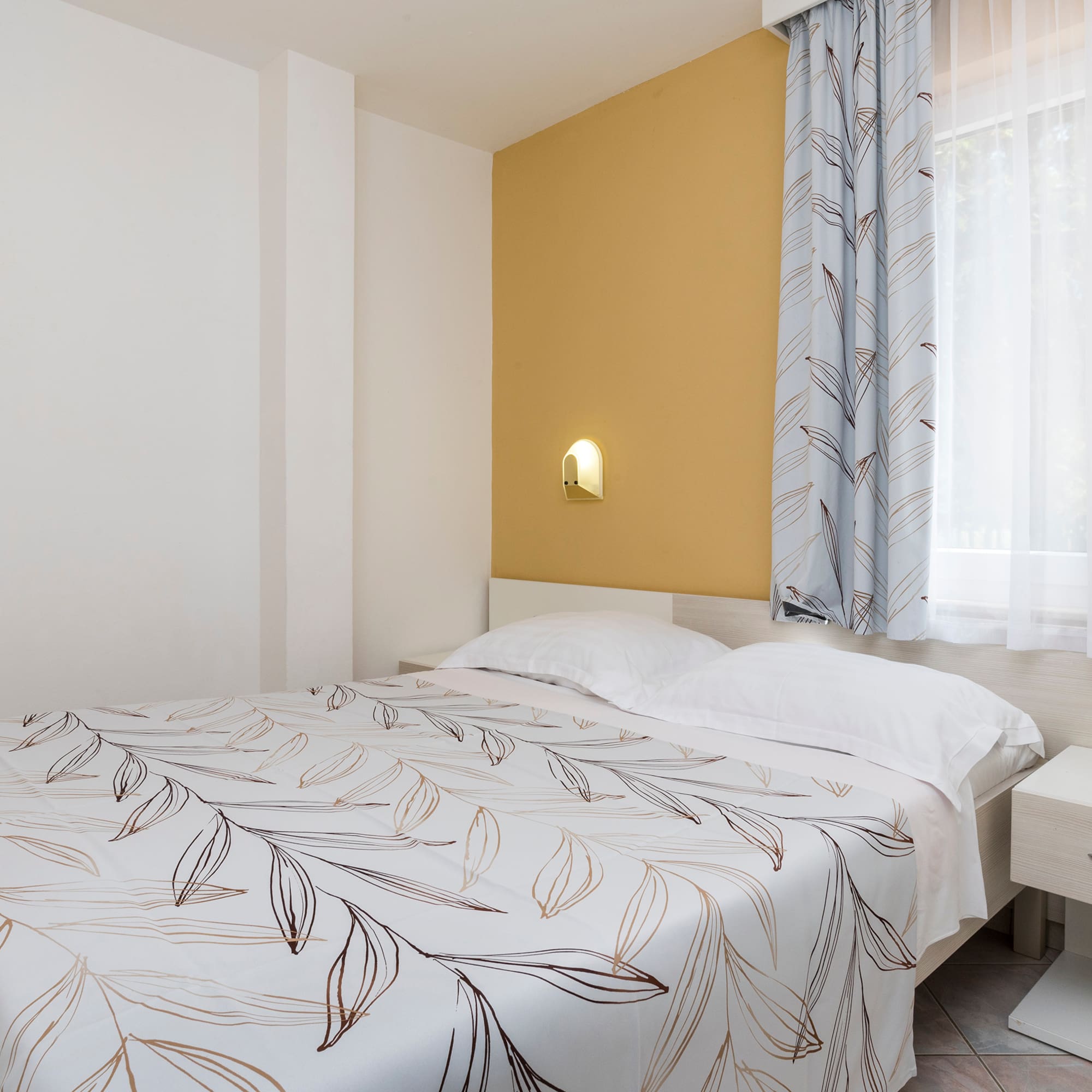 a bed with a white and brown blanket