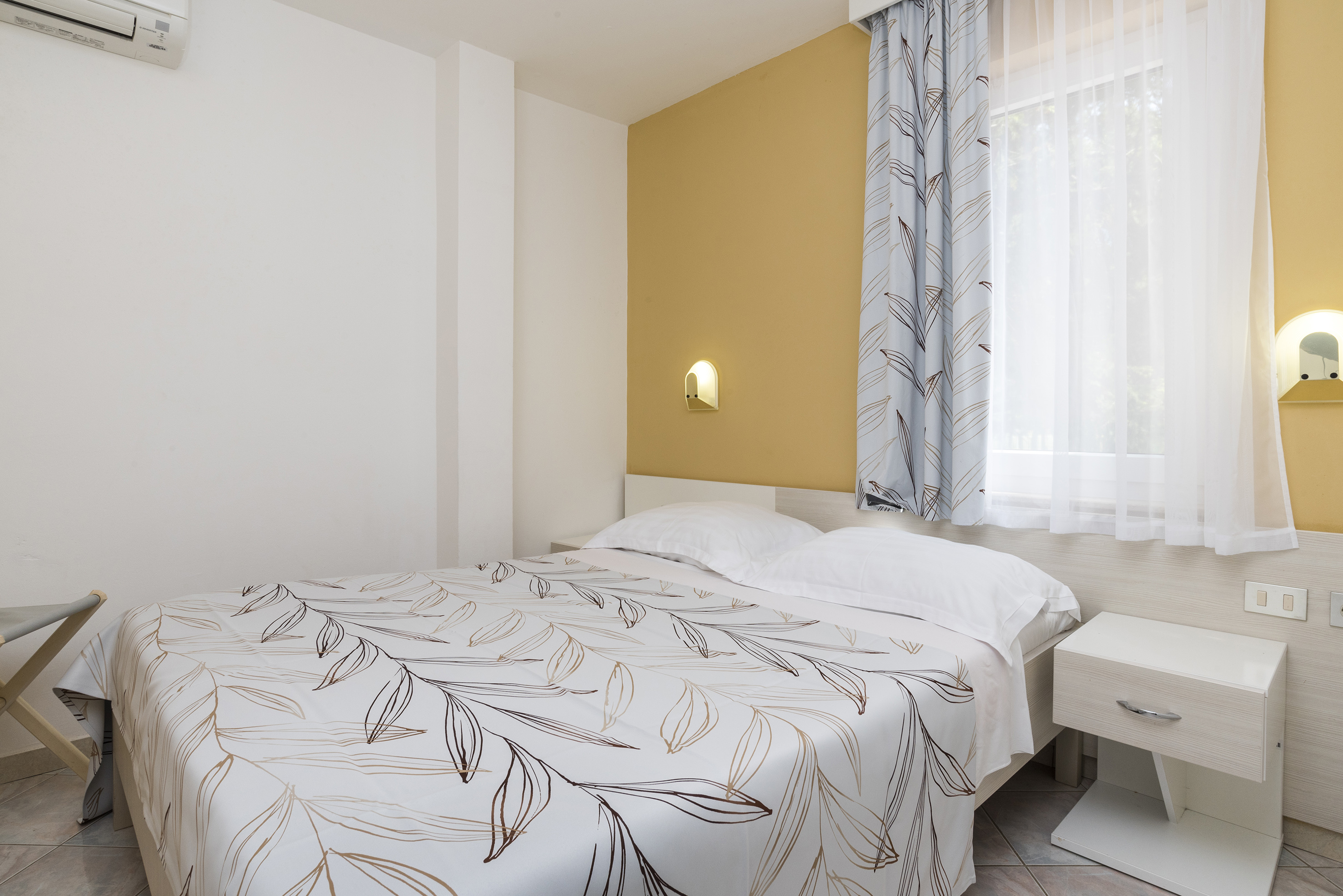 a bed with a white and brown blanket