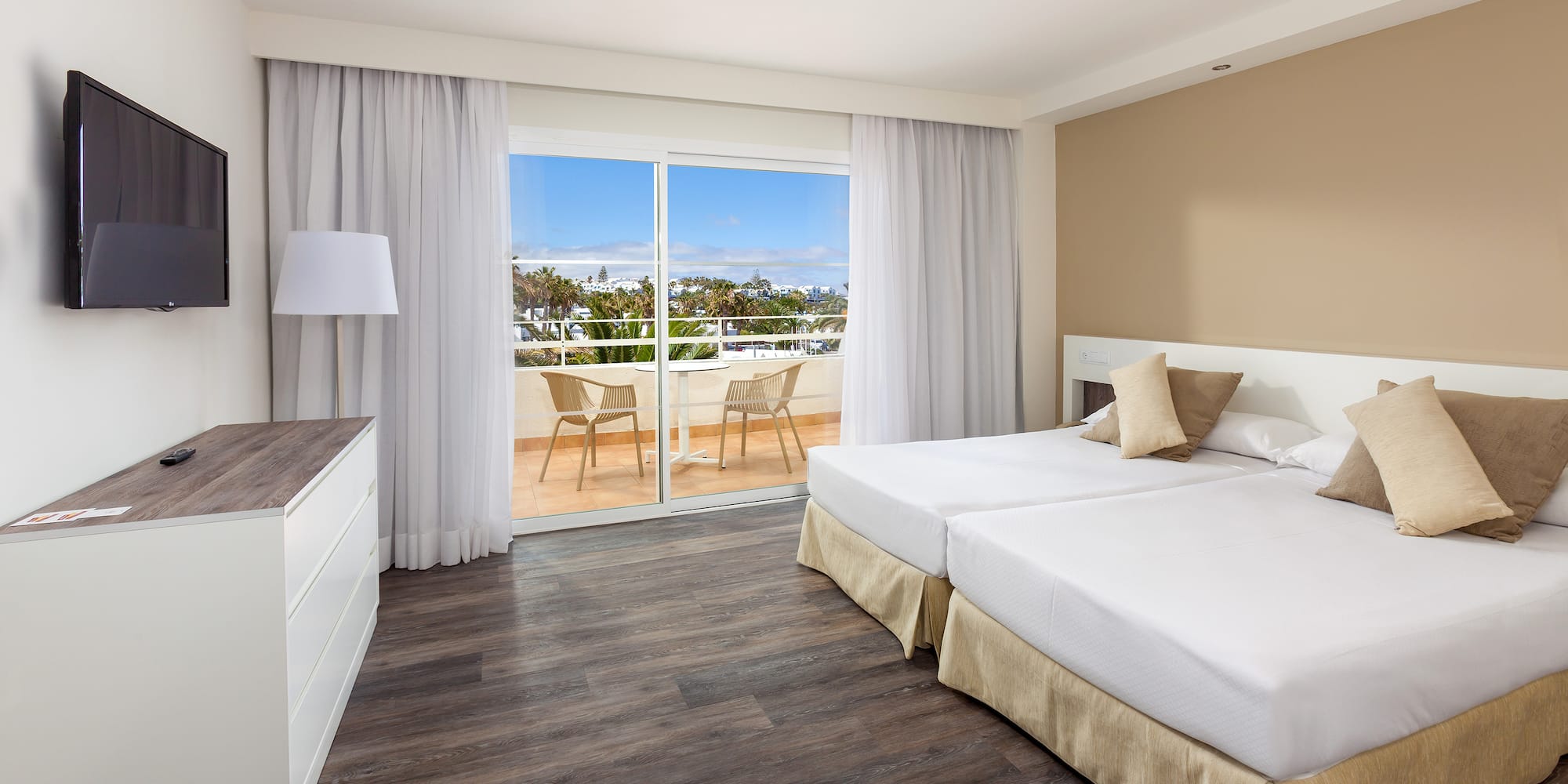 a room with two beds and a glass door