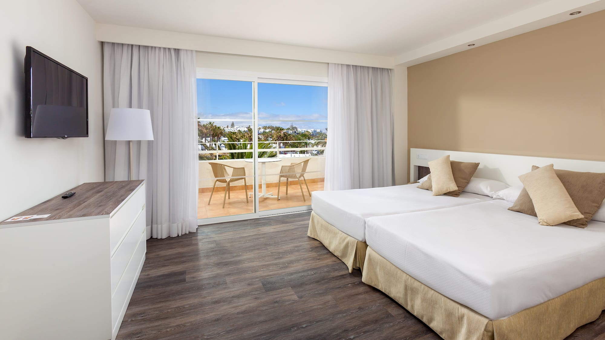 a room with two beds and a glass door