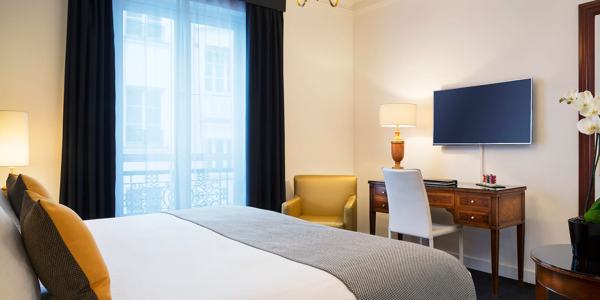 a bedroom with a bed and a desk and a tv