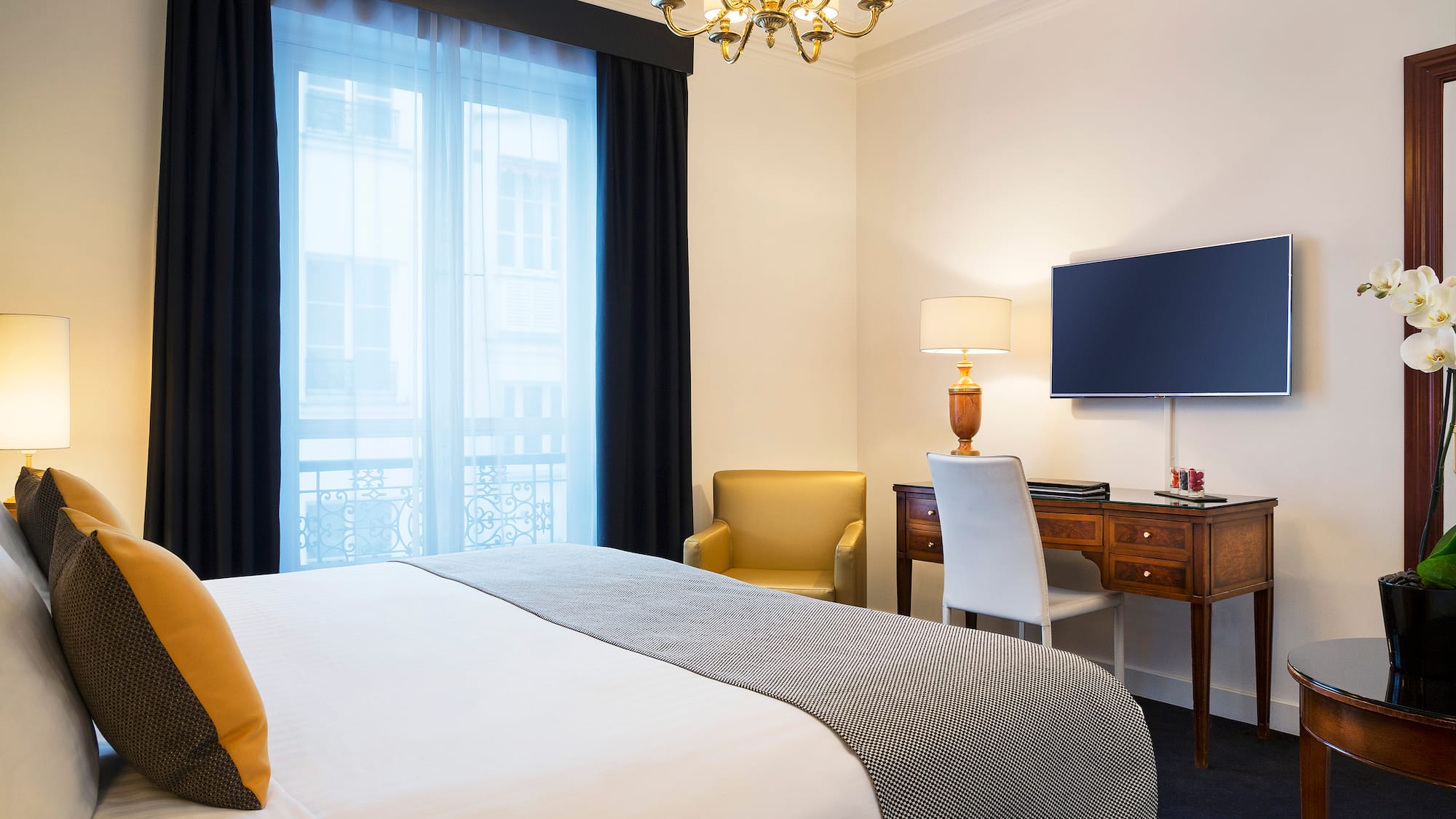 a bedroom with a bed and a desk and a tv