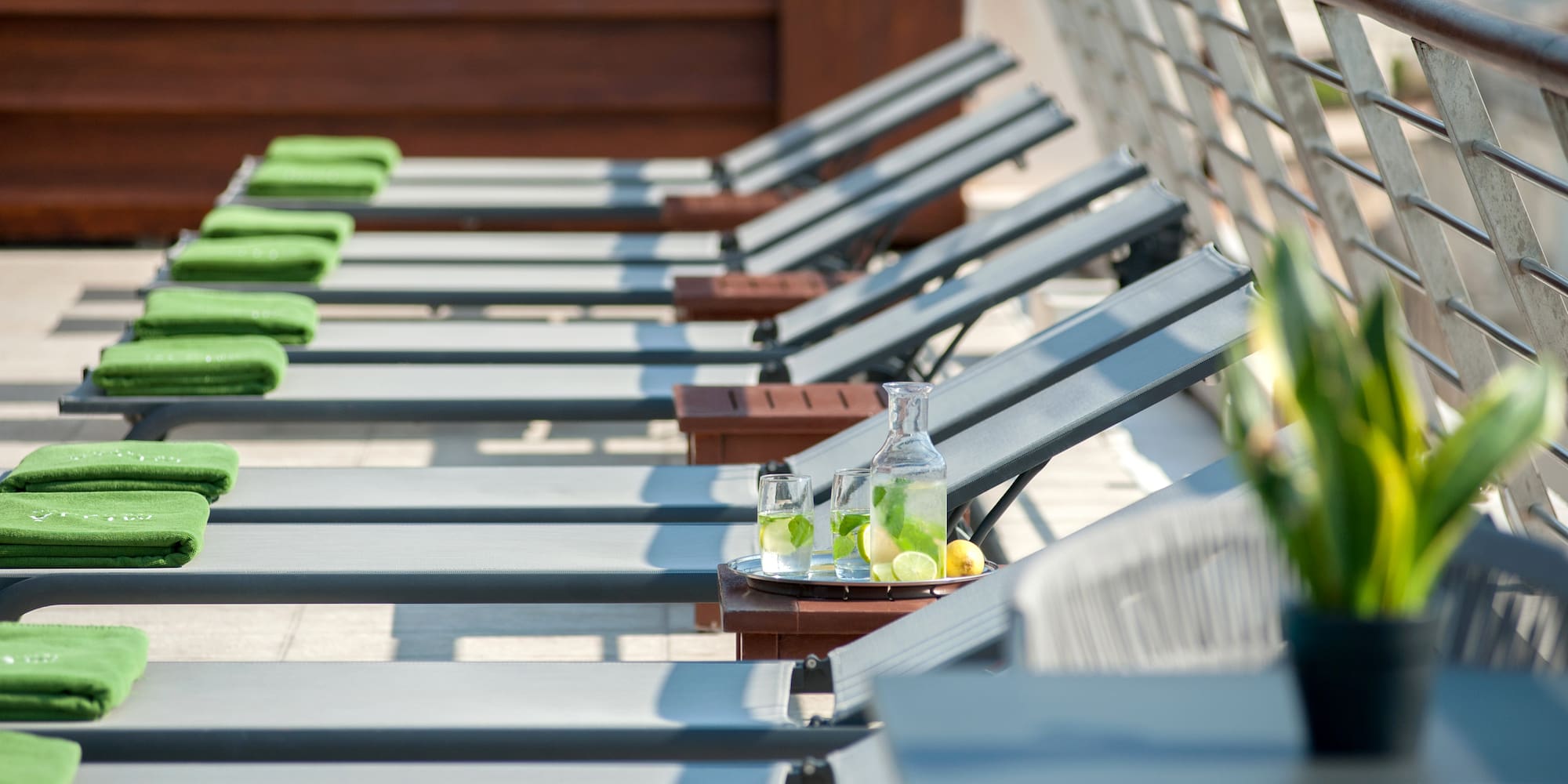 a row of lounge chairs with a tray of lemons and glasses