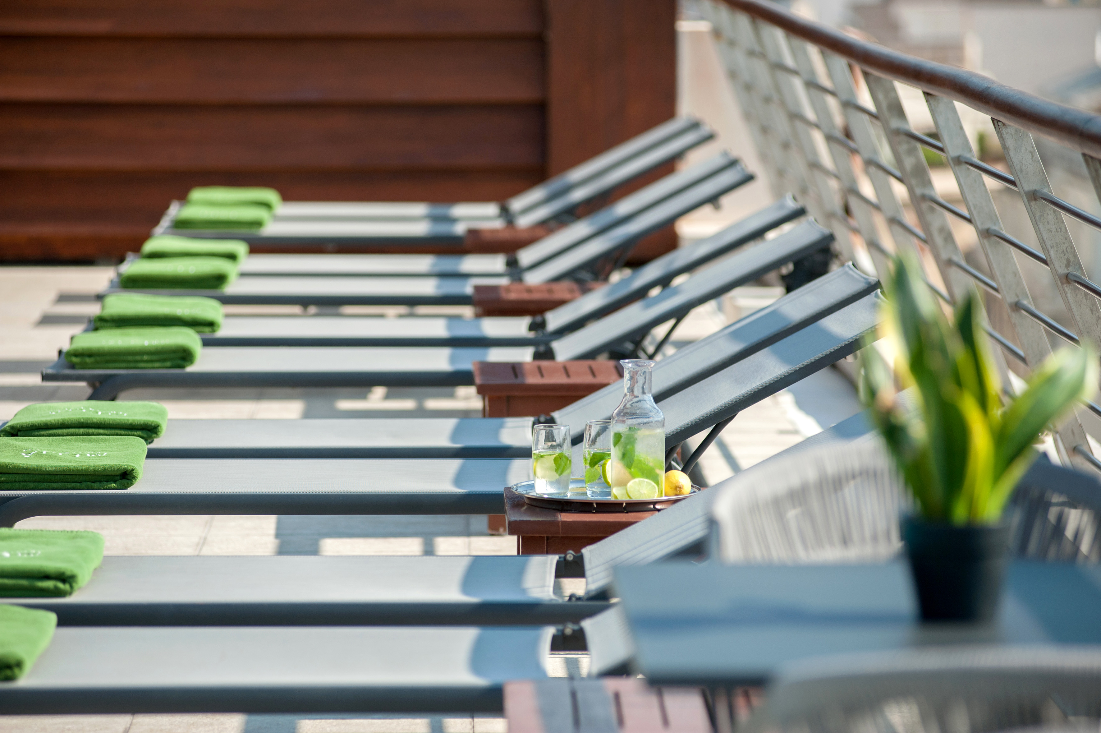a row of lounge chairs with a tray of lemons and glasses