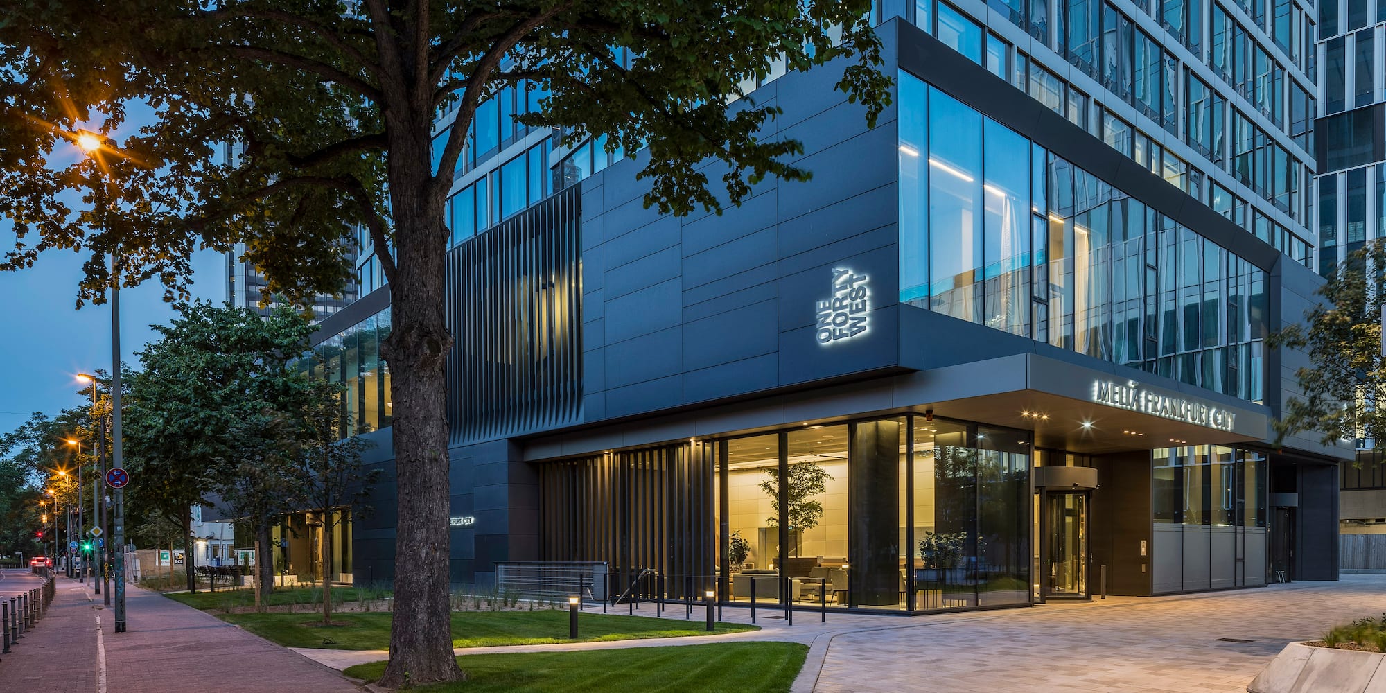 a building with glass windows and trees